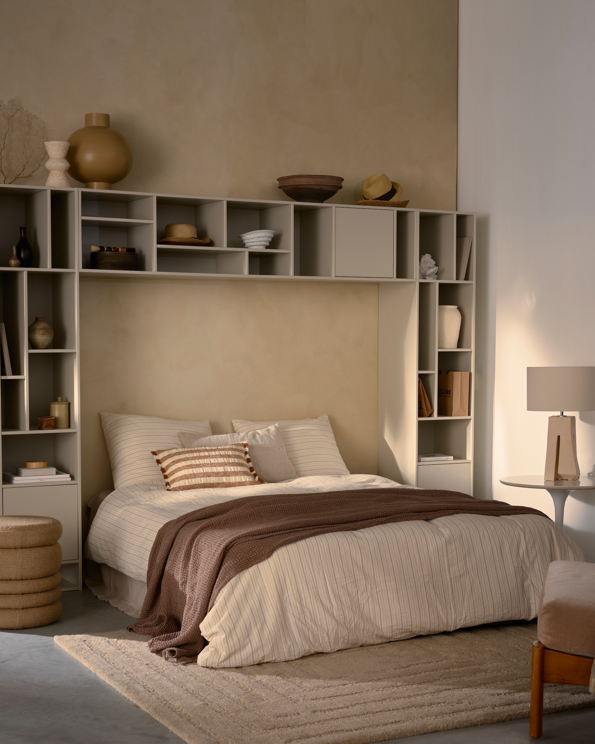 3x vtwonen meubel letterba(n)k XL, grenenhout, dust, 194x40x40 cm (bxdxh) € 399,- (inclusief kussen € 579,-).M.m.v. urbannatureculture.nl (vazen op bovenste rand en poef), cocooncollectables.nl (vintage vazen en lamp), zarahome.com (sierkussens, ronde dozen, beddengoed, sprei, papier-maché schaal), woood.nl (vloerkleed,  crème bijzettafel), . Overig privébezit. vtwonen 07-2025 | styling Cleo Scheulderman | fotografie Jeroen van der Spek