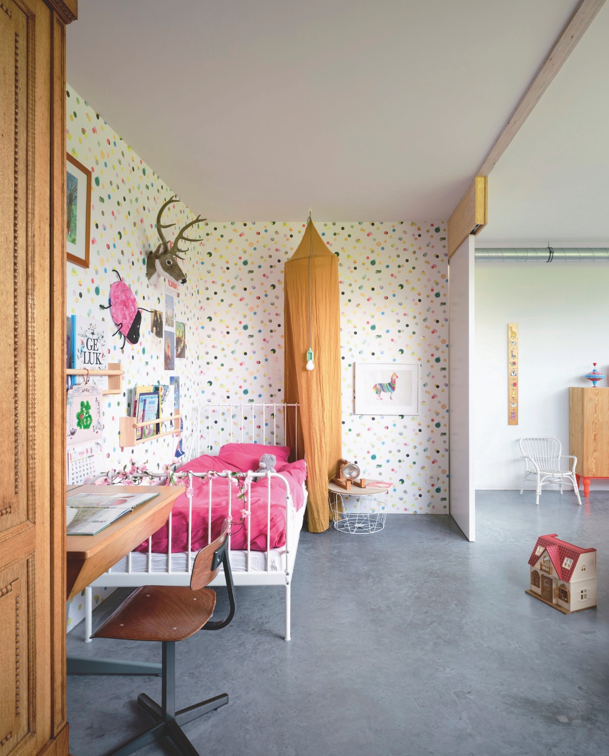 Houten kast erfstuk. Bureau en stoel tweedehands. Spijlenbed, beddengoed en wandrekken Ikea. Tafel Fonq. Behang Mini Me collectie van Eijffinger. Kunstwerk zelfgemaakt. vtwonen 05-2025 | fotografie Mr. Frank | tekstbewerking Britte Kramer