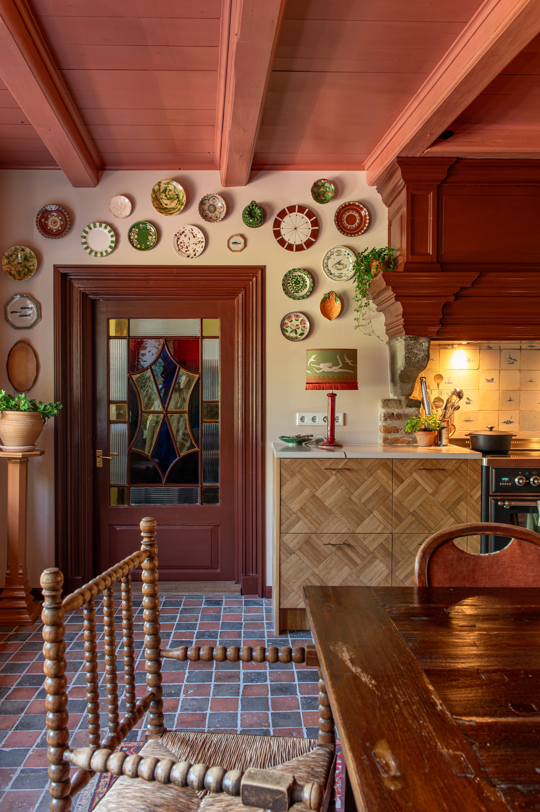 Muurkleur Beauvais Lilac van Little Greene, kleur op deur en schouw Deep Reddish Brown en kleur op plafond Loggia van Farrow & Ball. Stoelen tweedehands via kringloop en Marktplaats, tafel via Marktplaats. Lampenkap Palais, voet kringloop. Borden kringloop, Marktplaats, H&M Home, Zara Home, Jane Carefully Curated, Foodies in Heels en Lenta Living. Keukenfrontjes zelfgemaakt van antieke mozaïekvloer. Tweedehands fornuis Boretti via Marktplaats. vtwonen DIY special 03-2025 | fotografie Caroline Coehorst