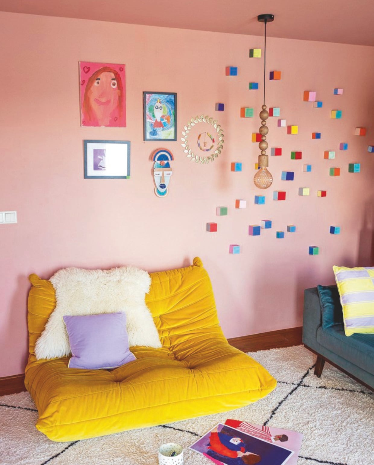 Bank Togo van Ligne Roset. Roze schilderij en Sinterklaas-tekening zelfgemaakt. Schilderij spekjes Loods 5. Gouden cirkel met blaadjes Kwantum. Masker Studio Roof. Blokjes op muur van een kunstenaar via Etsy. Gestreept kussen Zeeman. Hanglamp Kwantum vtwonen 05-2025 | styling Ilona Jongepier | fotografie Dana van Leeuwen