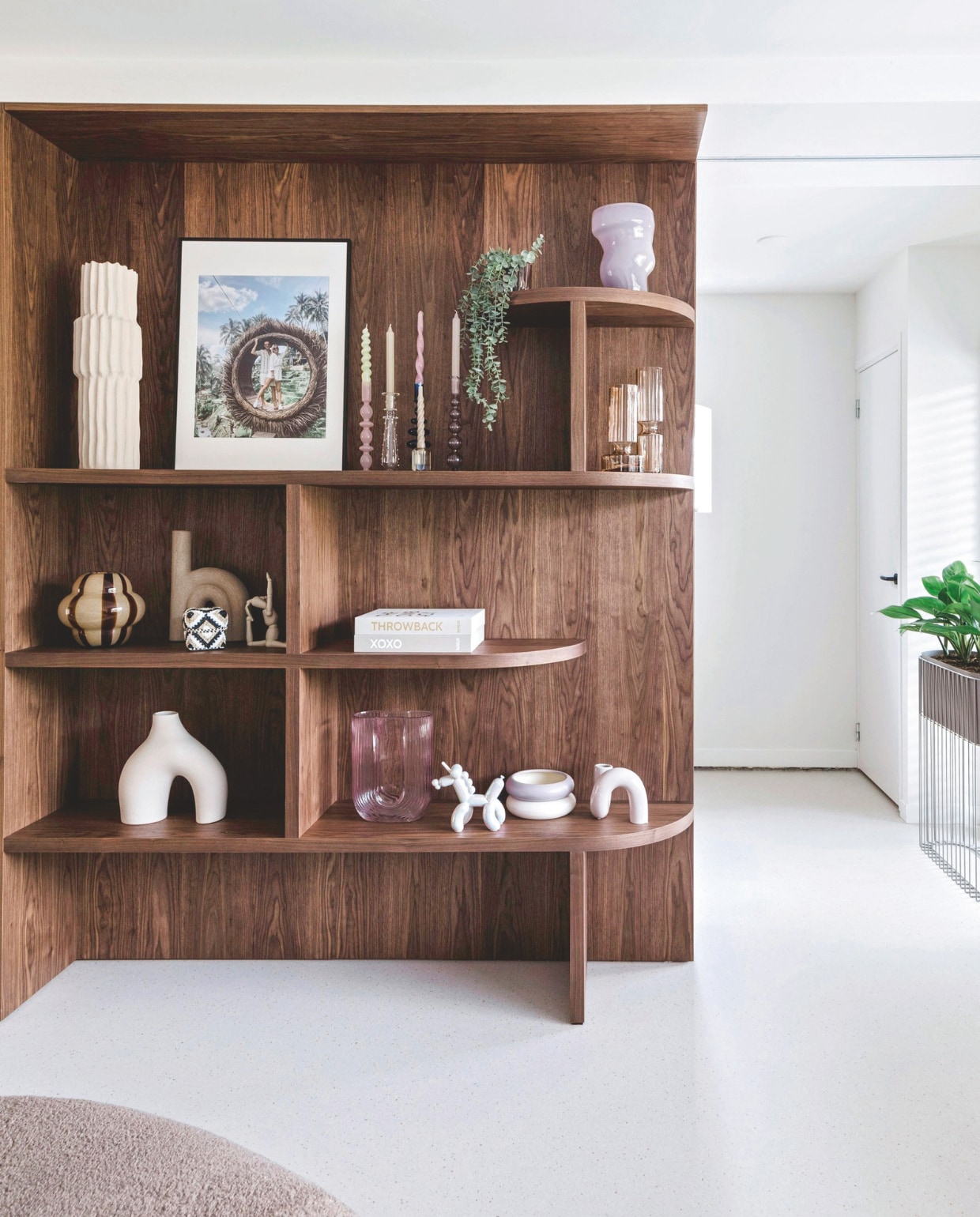 Maatwerk kastenwand MK Interieur en Timmerwerken. Bruine vazen Broste Copenhagen, kandelaars Anna + Nina, gestreepte camel vaas ByOn, beige vaas onder H&amp;M Home, fotoboeken Bga. Overige accessoires Complot Concept Store. vtwonen 05-2025 | fotografie Corine Hoge Bavel