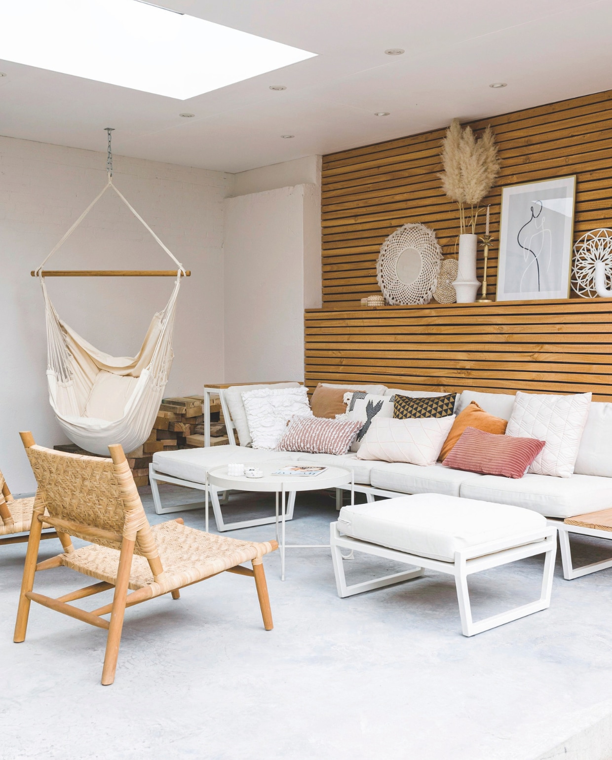 Houten wand, bank en hocker zelfgemaakt door Sjors. Rugkussens bank en tafel Ikea. Overige kussens groothandel, rieten stoelen Intratuin, accessoires Complot Concept Store. vtwonen 05-2025 | fotografie Corine Hoge Bavel