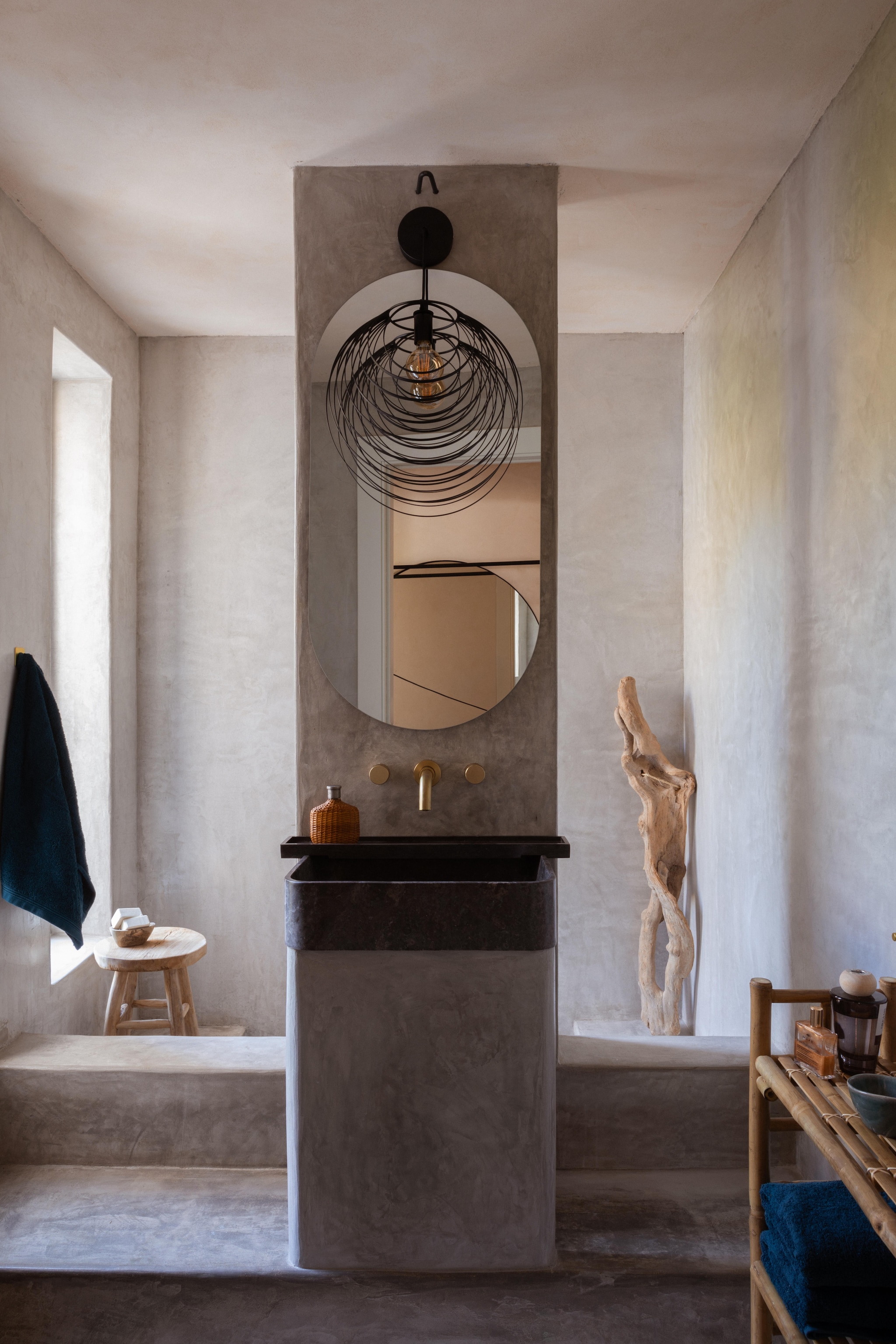 Muren en vloer Light Grey Quartz. IJzeren hanglamp Olenka Interiors. Wastafel donker Emperor-marmer van Leo & Martino Pietra. vtwonen 08-2025 | productie Living Inside | fotografie Monica Spezia