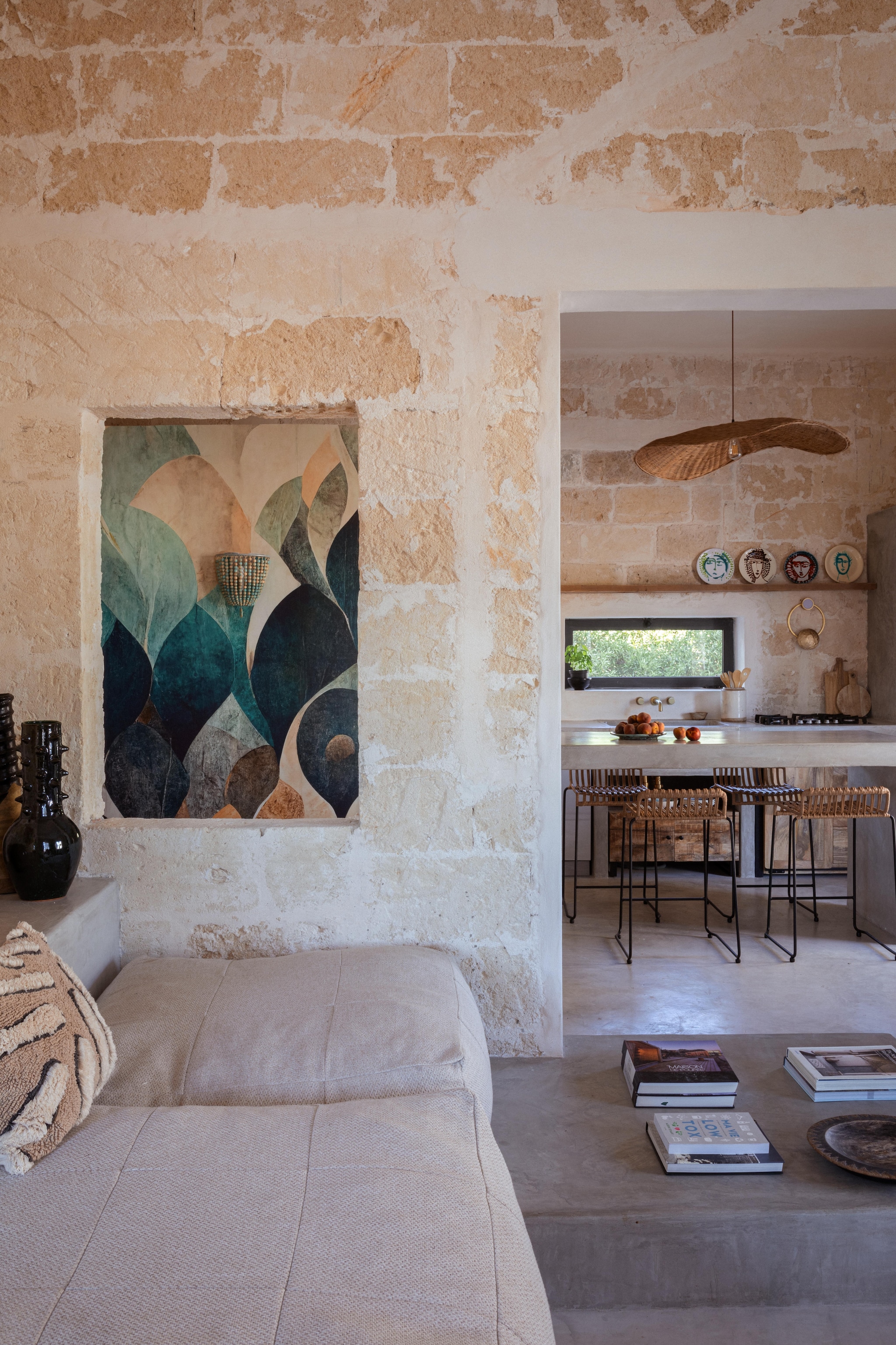 Linnen gordijnen handgemaakt. Linnen zitmeubels en poefen Olenka Interiors. Plaid Maisons du Monde. Artistiek keramiek en vloerkleed uit Marrakesh. Vloer en tafel van kwarts. Hoge krukken Sklum. Lichtgroene koffiezetter Power Espresso van Cecotec. Rattan hanglamp uit Marrakesh. Behang Dry Leaves van Wallism. vtwonen 08-2025 | productie Living Inside | fotografie Monica Spezia