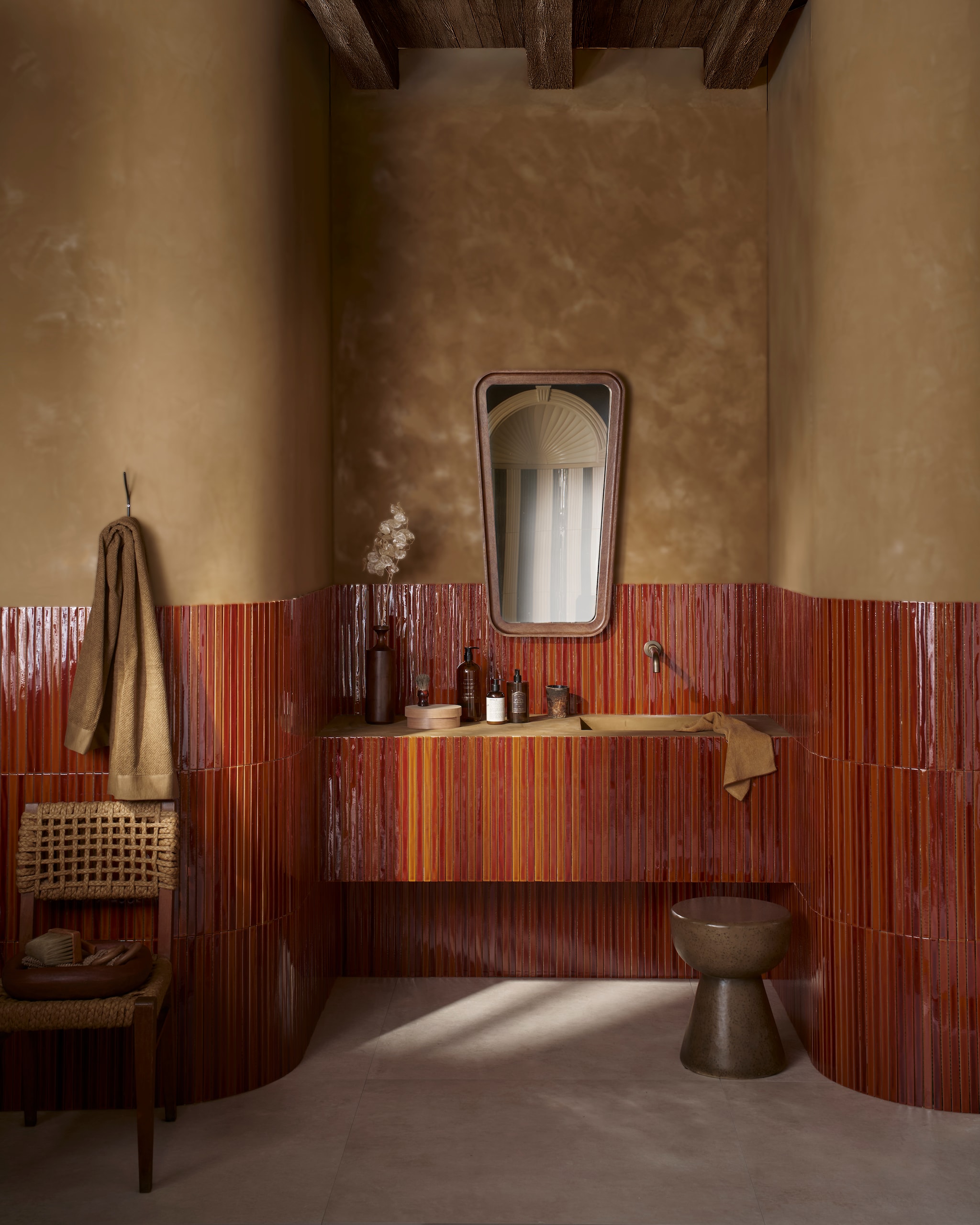 Op de wand: vtwonen wandtegel Rib, honey crackle glans, 13,4x45 cm, per stuk € 9,95. Op de vloer: vtwonen vloer- en wandtegel Noble, sand, 100x100 cm, per m² € 76,-. M.m.v. bestwelhip.nl (stoel), lauthentique.nl (kalkverf Oker 153), zarahome.com (spiegel, wandhaak, badlakens, badproducten), hkliving.com (kruk, houten schaal). Overig privébezit. vtwonen 08-2025 | styling Cleo Scheulderman | fotografie Jeroen van der Spek