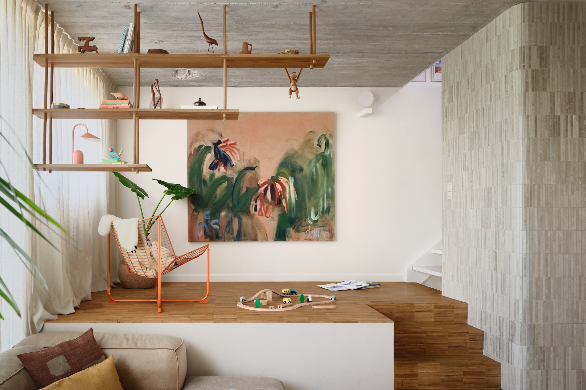 Dankzij de vele niveauverschillen voelt het huis verrassend aan. Met verschillende hoekjes, zoals het podium dat de Bond Shelf van Fogia, Skalboda-stoel van Ikea en het schilderij van Louise Van Hemeldonck mooi uitlicht. stijlvol wonen 7-2025 | fotografie Mr. Frank