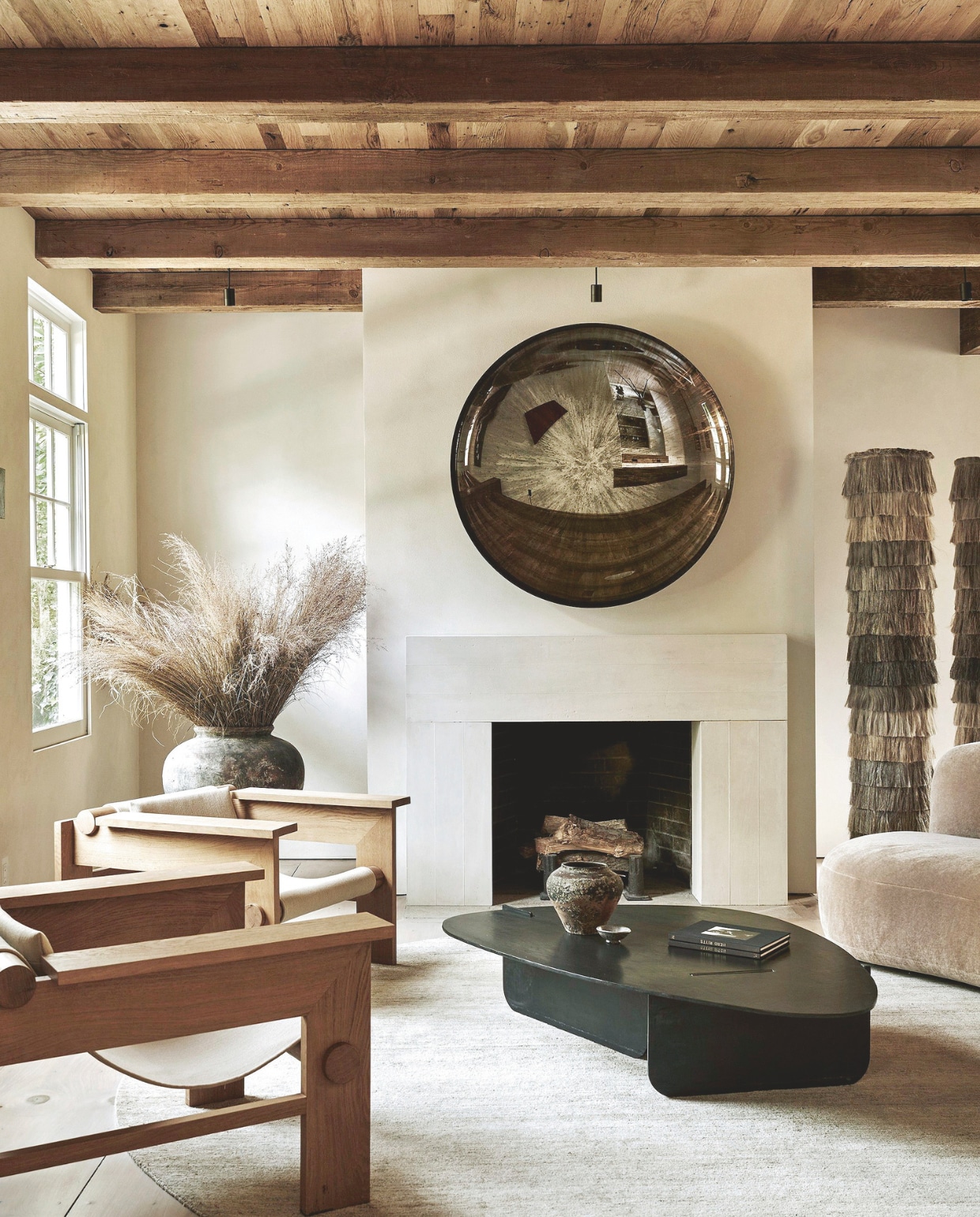 Vloer en balken hergebruikt hout. Sculptuur Peter Brooke-Ball. Bank Palais Royal van Pierre Augustin Rose in stof Opio van Pierre Frey. Fauteuil Karibu van Jiun Ho in leer Mr. Hide kleur Latte van Jerry Pair. vtwonen Landelijk 05-2025 | styling Colin King | fotografie Adrian Gaut  | tekstbewerking Margreet van Schaik