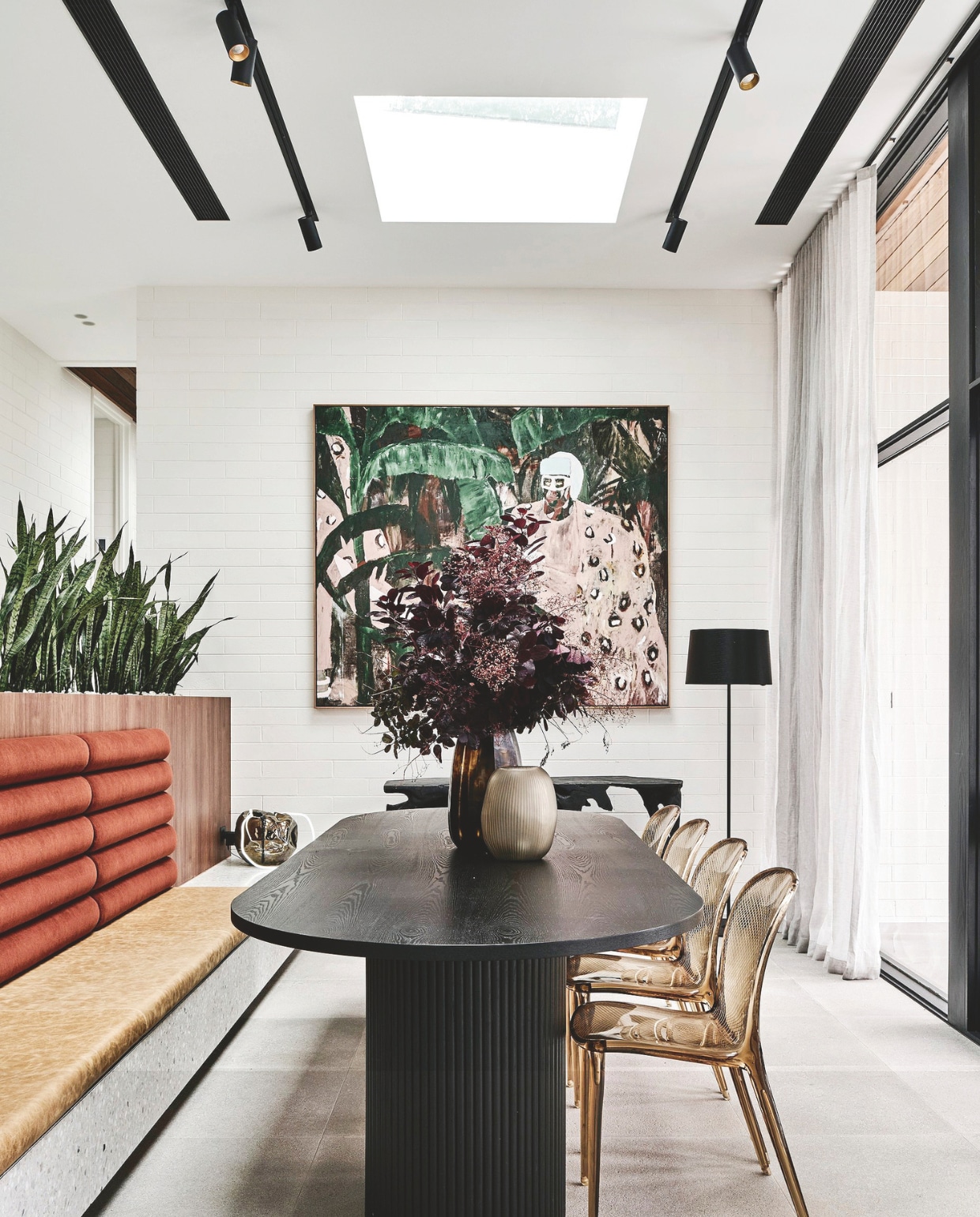 Bank op maat gemaakt. Transparante stoelen Kartell. Muurverf Natural White van Dulux. Kunstwerk van Stanislas Piechaczek. Stijlvol wonen 05-2025 | fotografie Tom Blachford | tekstbewerking Evelien Roels