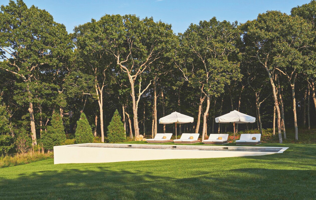 Het stucco zwembad is, in tegenstelling tot het traditionele huis, modern design. Op maat gemaakte parasols Santa Barbara Designs. vtwonen Landelijk 05-2025 | styling Colin King | fotografie Adrian Gaut  | tekstbewerking Margreet van Schaik