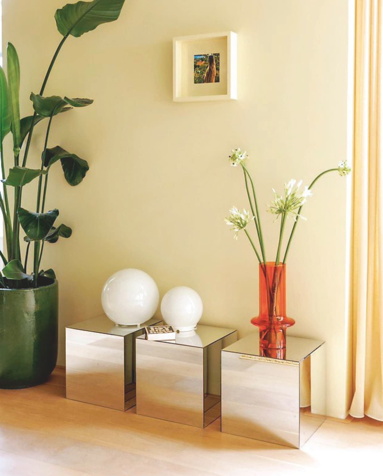 Muurkleur Asian Sunrise van Lab Paint. Lijst Ikea geschilderd in dezelfde kleur lak. Bollampjes Ikea. Vaas Urban Nature Culture. Spiegeltafeltjes Ikea hack. vtwonen 06-2025 | styling Kelly Van Gendt | fotografie Emma Peijnenburg