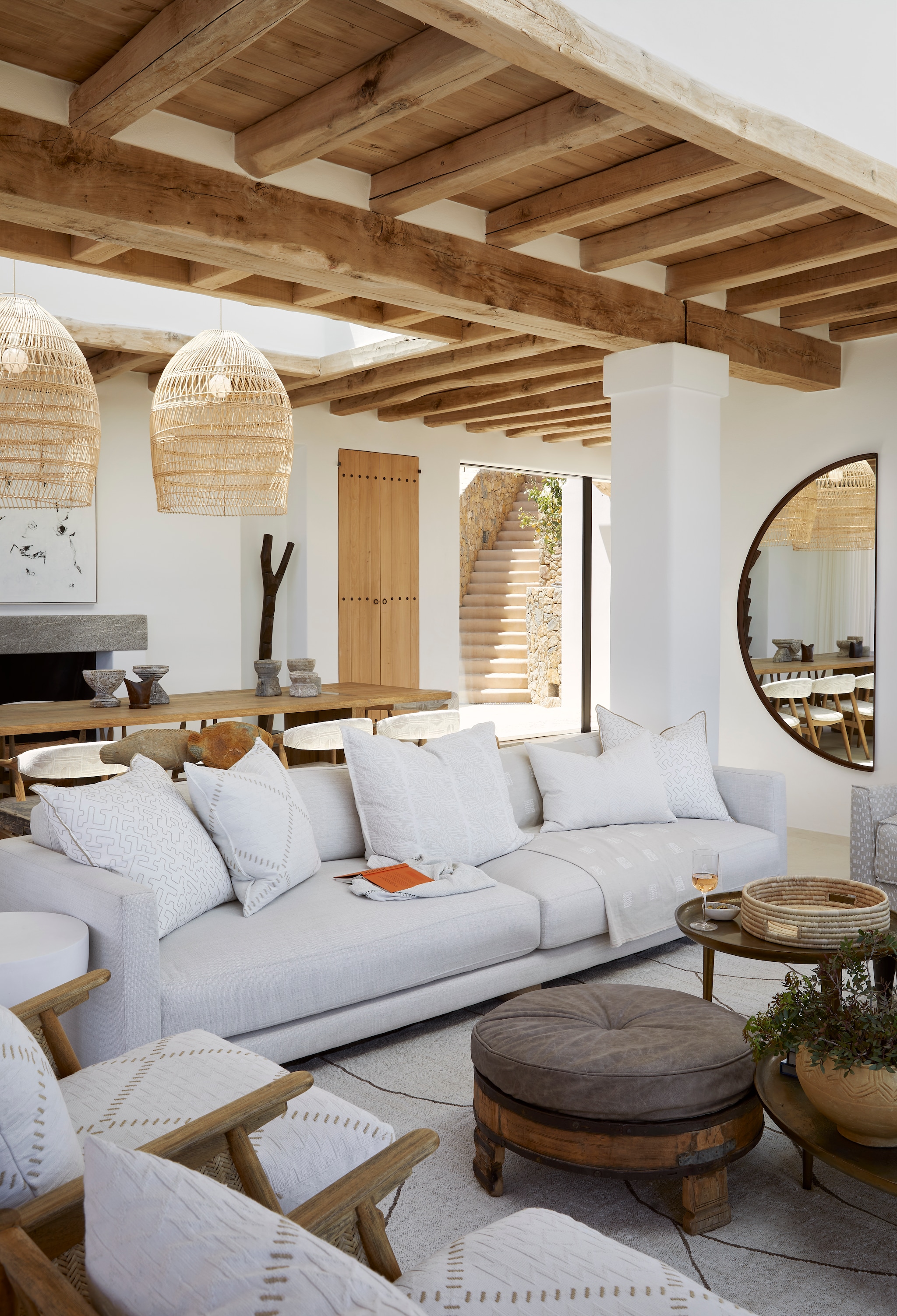 De tv-hoek met juten tapijt uit Zuid-Afrika, op maat gemaakte bank, kussens Romo Fabrics, antieke houten graanmolen als lampvoet, stoelen en bijzettafels La Grange Interiors. Kunstwerk Stanislaw Trzebinski. vtwonen Landelijk 08-2025 | fotografie Elsa Young | productie Living Inside
