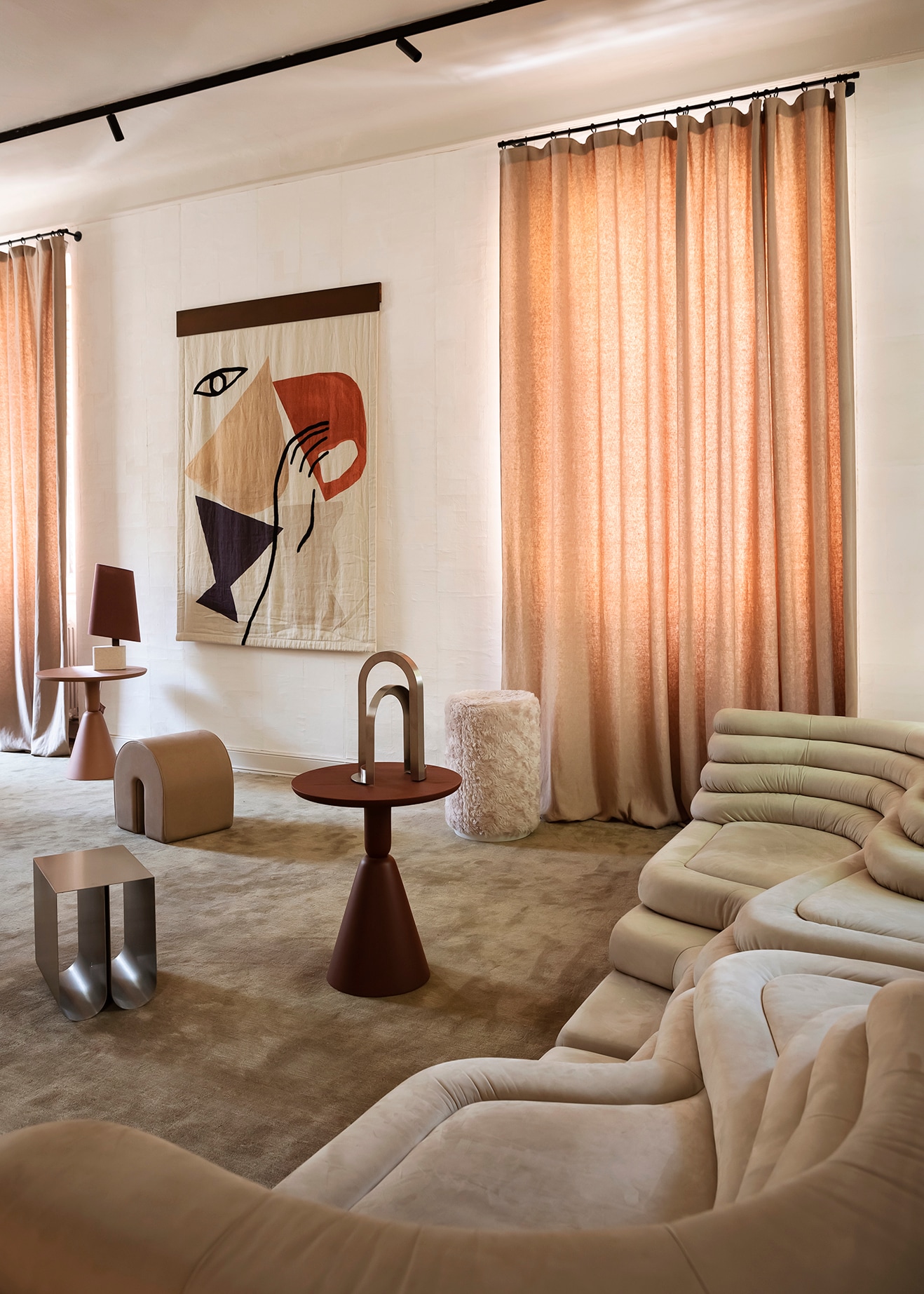 Poef Curved, sidetable Curved en rvs sculptuur Arch van Kristina Dam Studio. Links twee bijzettafels Pion van Sancal. Gordijn van Élitis, doek met tekening en sfeerlamp van Once Milano. Stijlvol Wonen 8-2025 | fotografie Silvia Sirpresi | productie Studiopepe