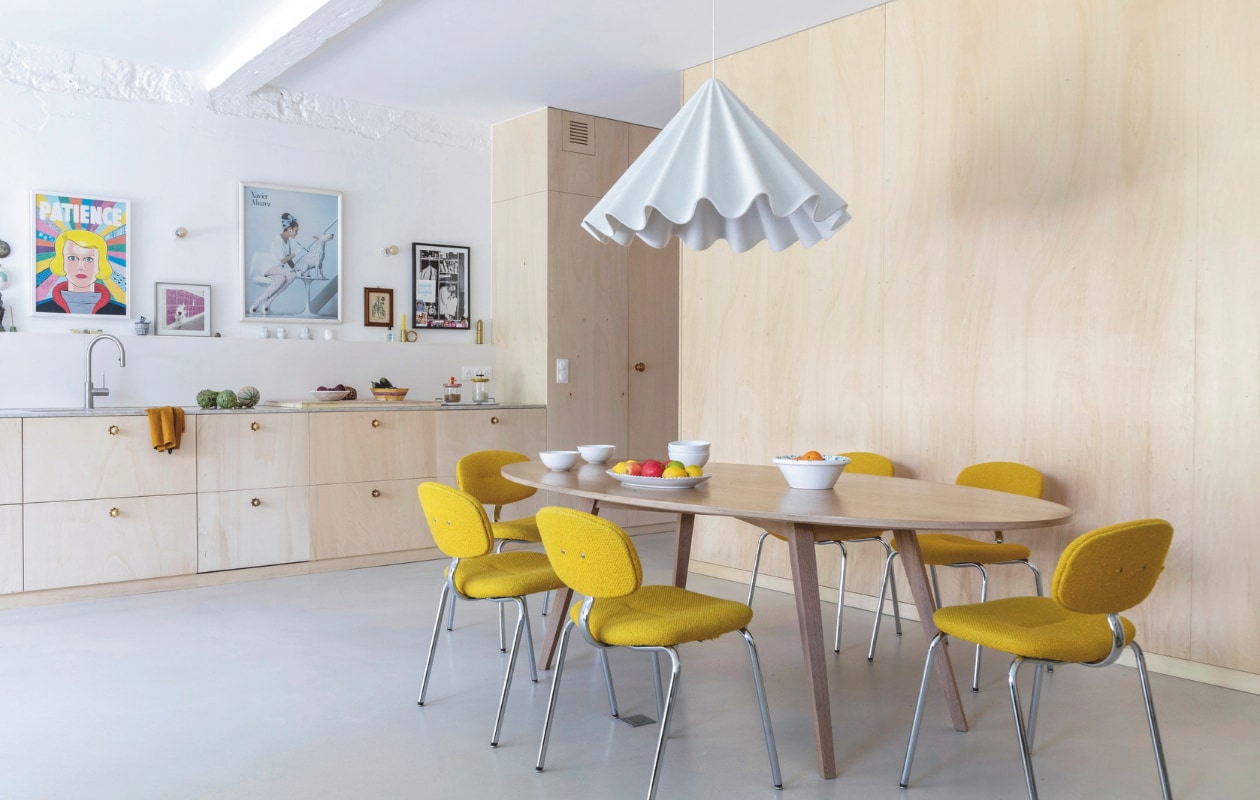 Eettafel Orphie, stoelen Pierre Paulin, keuken op maat gemaakt, poster Patience uit boek Daniel Clowes, hanglamp Audo Copenhagen. vtwonen 06-2025 | productie AC Scoffoni | styling Marie-Maud Levron | fotografie Cécile Perrinet Lhermitte