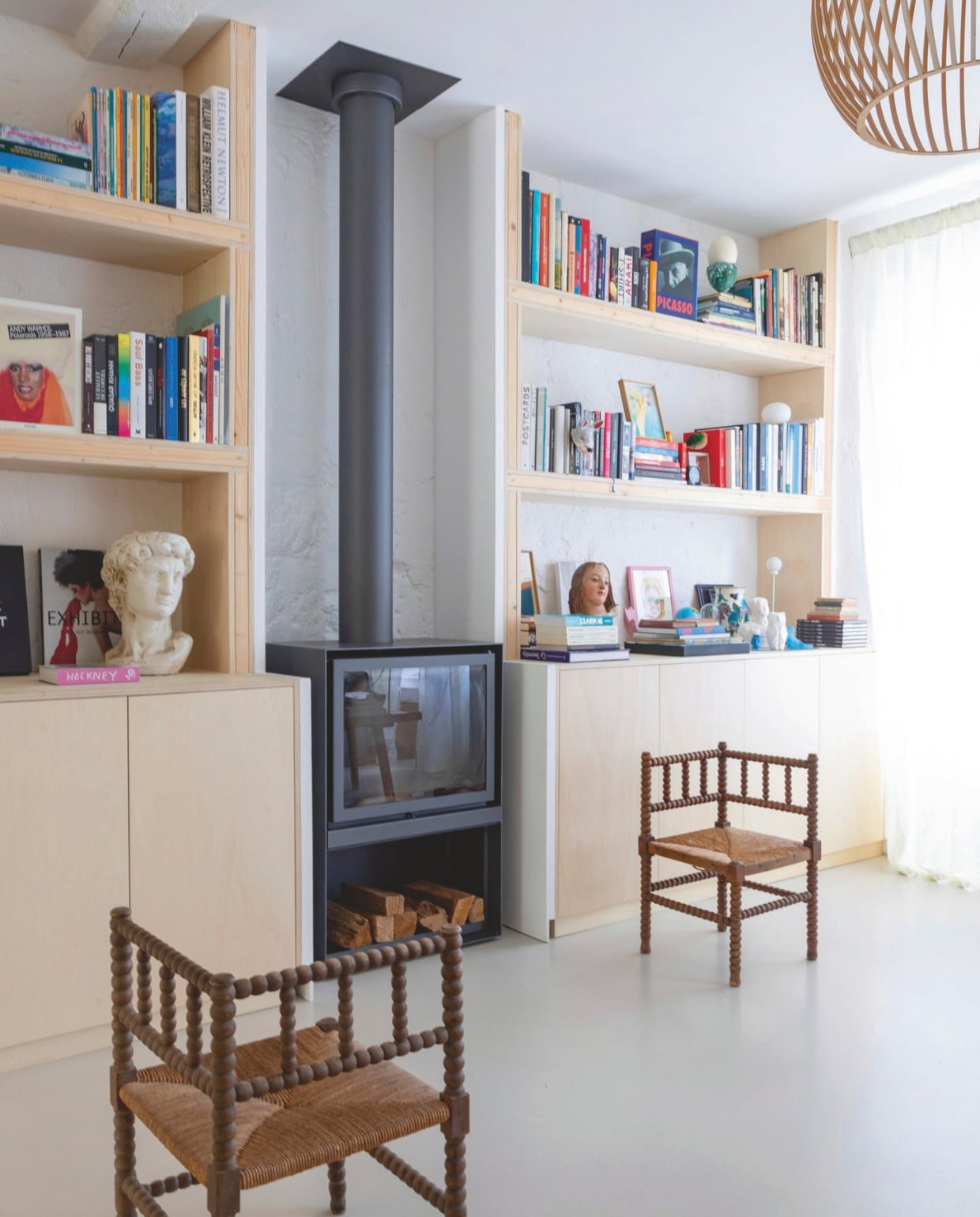 Wandkasten op maat gemaakt, haard Stûv, stoelen tweedehands, buste markt in Nogent-Le-Rotrou, hanglamp Octo 4240 van Secto Design. vtwonen 06-2025 | productie AC Scoffoni | styling Marie-Maud Levron | fotografie Cécile Perrinet Lhermitte