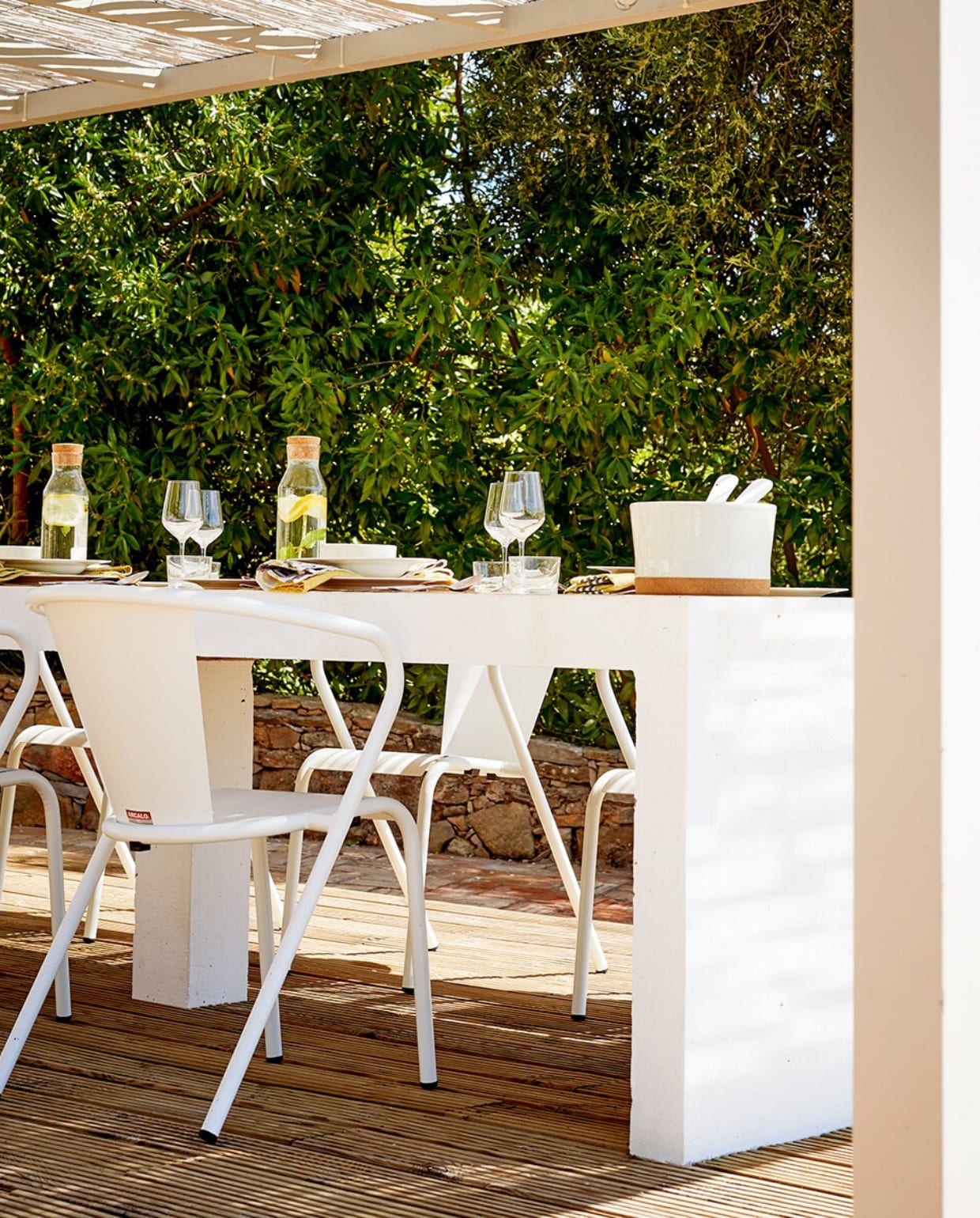 Aan tafel staan de iconische Gonçalo-terrasstoelen van het Portugese Arcalo. vtwonen tuin special 2 2020 | productie Features &amp; More | styling Wilma Custers | fotografie Renée Frinking