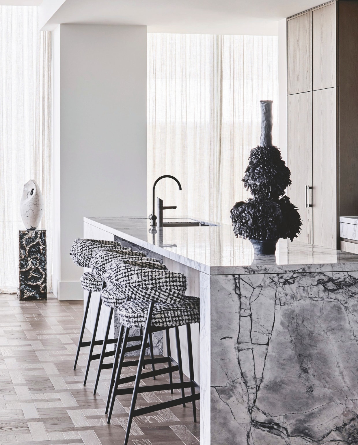 In de keuken borduurde Simone qua styling voort op het zwart-witte marmer van het keukeneiland. Zo past de keramieken sculptuur van Lia Klugman bij krukken Nena van Zanotta, bekleed met stof van Dedar, én bij het keramiek op het aanrecht, van Juz Kitson via Sophie Gannon Gallery. Simone: ‘Wees niet bang om ook op het aanrecht sculpturen tentoon te stellen.’ Stijlvol Wonen 05-2025 | styling Simone Haag | fotografie Tom Blachford