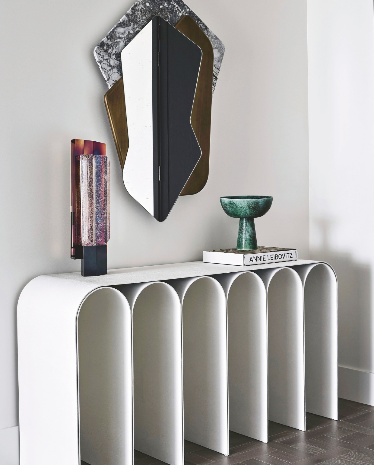 Simone: ‘In de entree van het appartement was alleen plek voor een smal, maar impactvol item. Deze stenen console vonden we in Parijs.’ Spiegel Cam van Tommaso Spinzi. Dressoir White Arch van Pietro Franceschini en tafellamp Rigel van SB26 via Moebel. Keramiek via Becker Minty. Stijlvol Wonen 05-2025 | styling Simone Haag | fotografie Tom Blachford