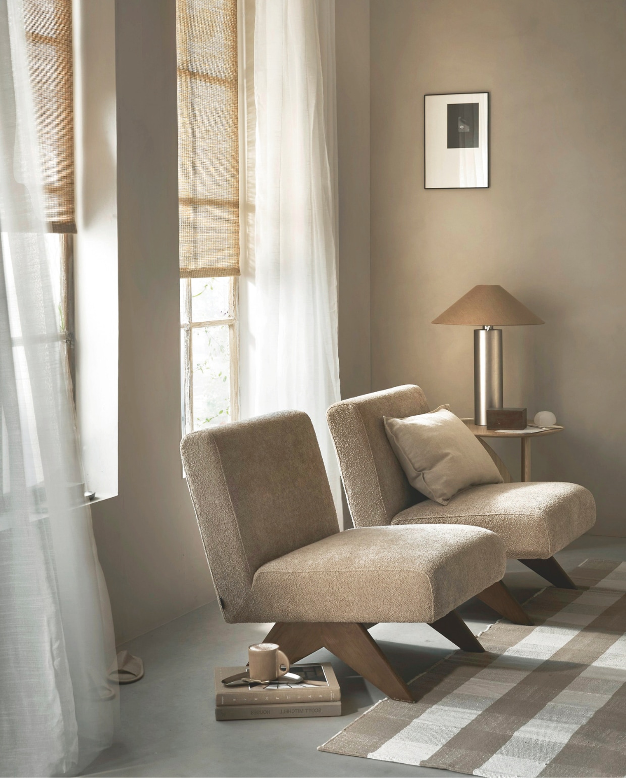 Lichtdoorlatend rolgordijn Aftersun, 60x190 cm (bxh) € 63,99 en halftransparant gordijn Frost in Wit, met plooi, 140x270cm (bxh) € 50,99. M.m.v. vestingh.nl (kalkverf Chalk van Lab in Fez), loods5.nl (fauteuil Marisa), ethnicraft.com (bijzettafel Alain van Havre), zarahome.com (tafellamp, ronde albasten lamp, fotolijst, dienblad, pantoffels, houten doos), hm.com (vloerkleed, mok, kussenhoes). Overig privébezit. vtwonen 06-2025 | styling Sanne Ketelaar | fotografie Peggy Janssen