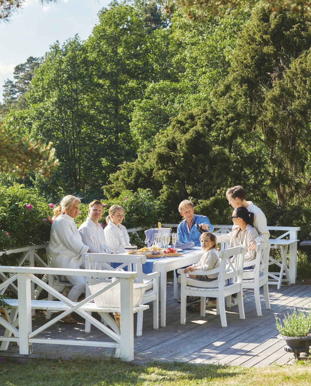 Het terras bij de rozenstruiken. Witte stoelen van Deens design. vtwonen Landelijk 05-2025 | fotografie Birgitta Wolfgang Bjørnvad