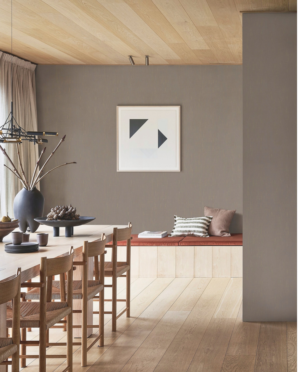 Behang Linnen in Mirre, 53 cm x 10 m (bxl), per rol € 33,99.M.m.v. zarahome.com (schaal links, kussens), 101cph.com (schaal op poten Duck Plate, vaas Sumo), moooi.com (hanglamp Tinkering van Joost van Bleiswijk). Overig privébezit. vtwonen 06-2025 | styling Kim van Rossenberg | fotografie Sjoerd Eickmans