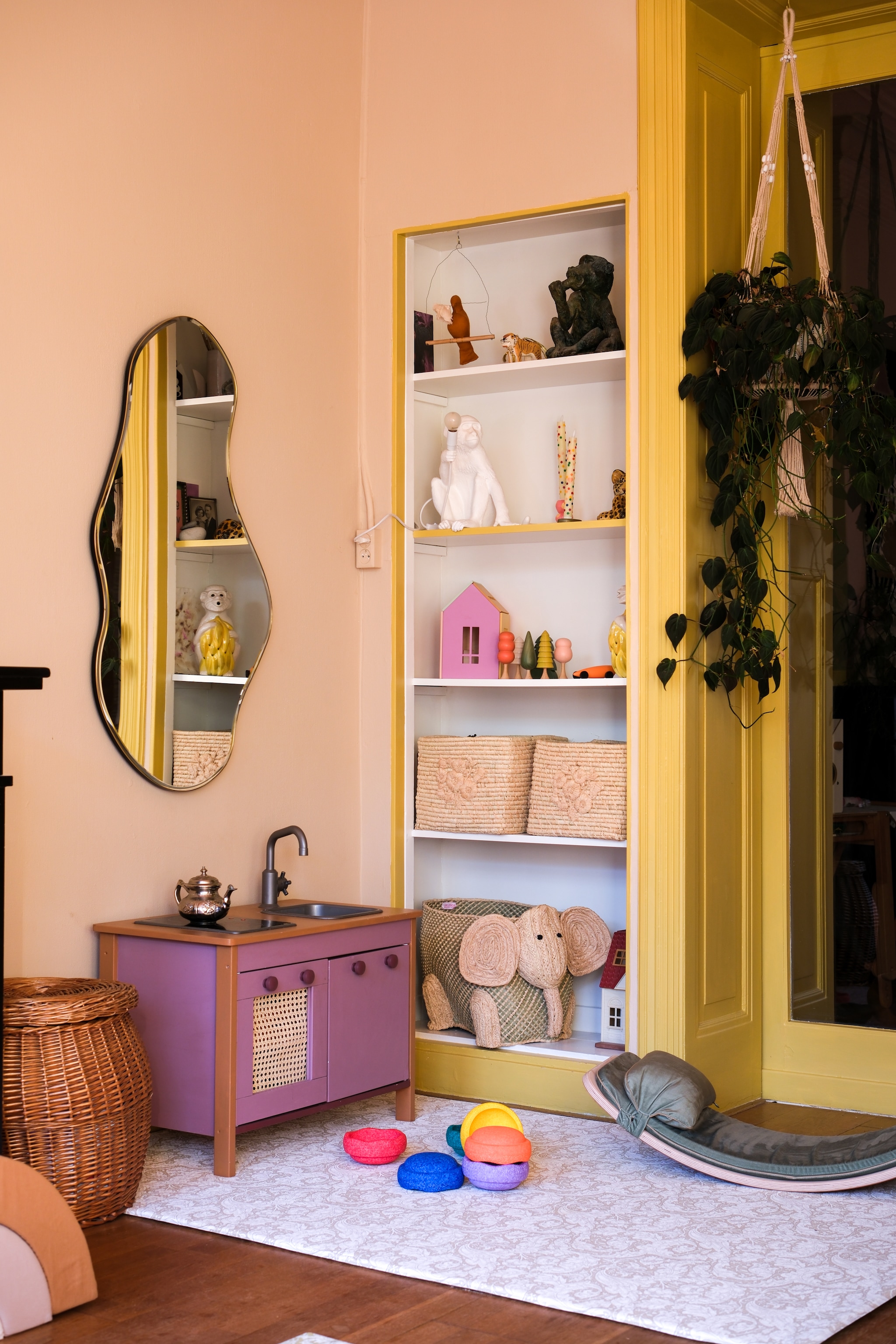 Aaplamp Seletti, houten bomen Hersin, houten huis Babai en opbergmanden Rice. Speelmat Totter+Tumble, stapelstenen Stapelstein, balansbord Wobbelboard. Spiegel Ferm Living. Muurverf Saint-Tropez, lak houtwerk Billy Button, beide van Lab Paint. Zelfgeschilderd keukentje Ikea. fotografie Rio van der Oest @mostlymosi