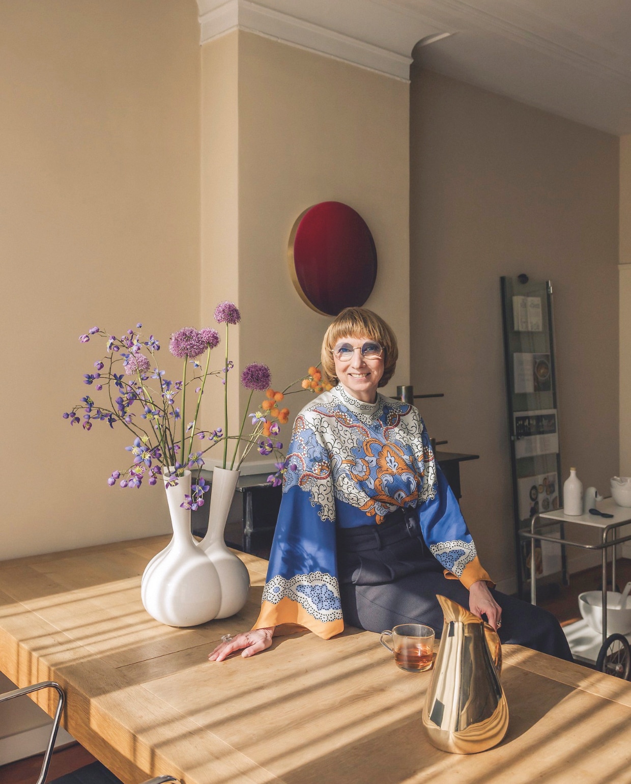 Tafel Henk Vos. Vaas Roderick Vos. Waterkan van Aldo Cibic voor Paola C. Het ronde wandelement is een kunstwerk van Corine van Voorbergen. Stijlvol Wonen 06-2025 | fotografie Katoo Peeters