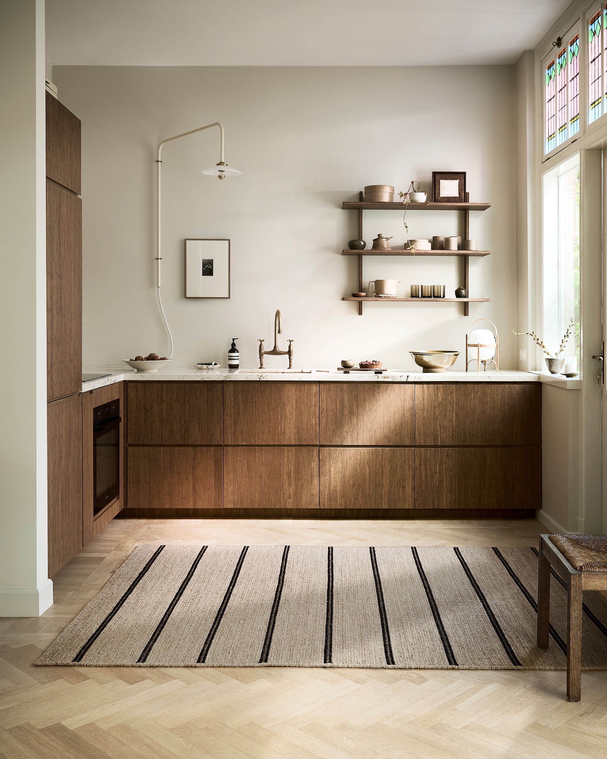 vtwonen vloerkleed Twin Stripe*, wol, sand, 160x230 cm € 299,-. M.m.v. valerie-objects.com (wandlamp), askogeng.no (keuken), floortjelouise.com (artwork wand), thefinestore.com (tafellamp, theepot, mokken), justanothershop.nl (artwork plank). Overig privébezit. vtwonen 9-2025 | styling Sanne Ketelaar | fotografie Peggy Janssen