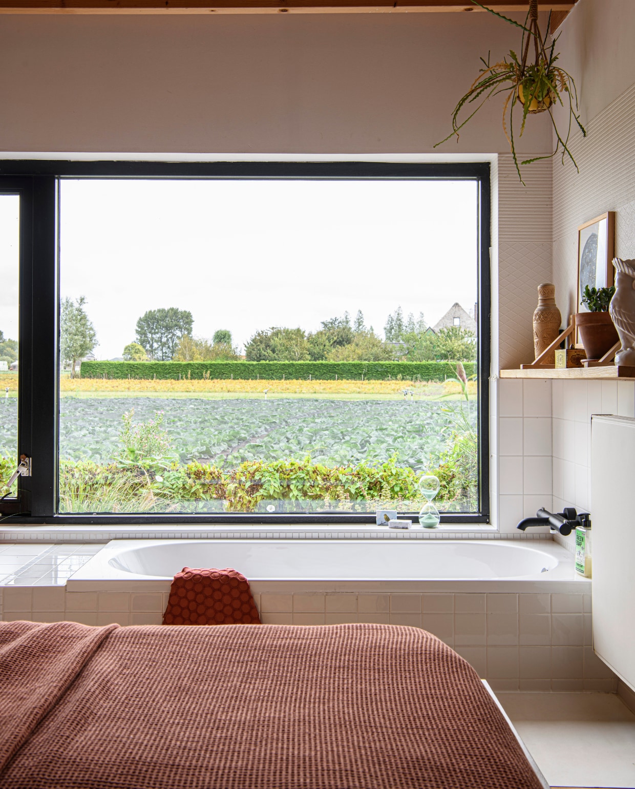 Het bad is verzonken, het bed staat juist op een verhoogd podium. Het hoogteverschil maakt het spannend. vtwonen 06-2025 | styling Fiona Richardson | fotografie Lisa Cohen