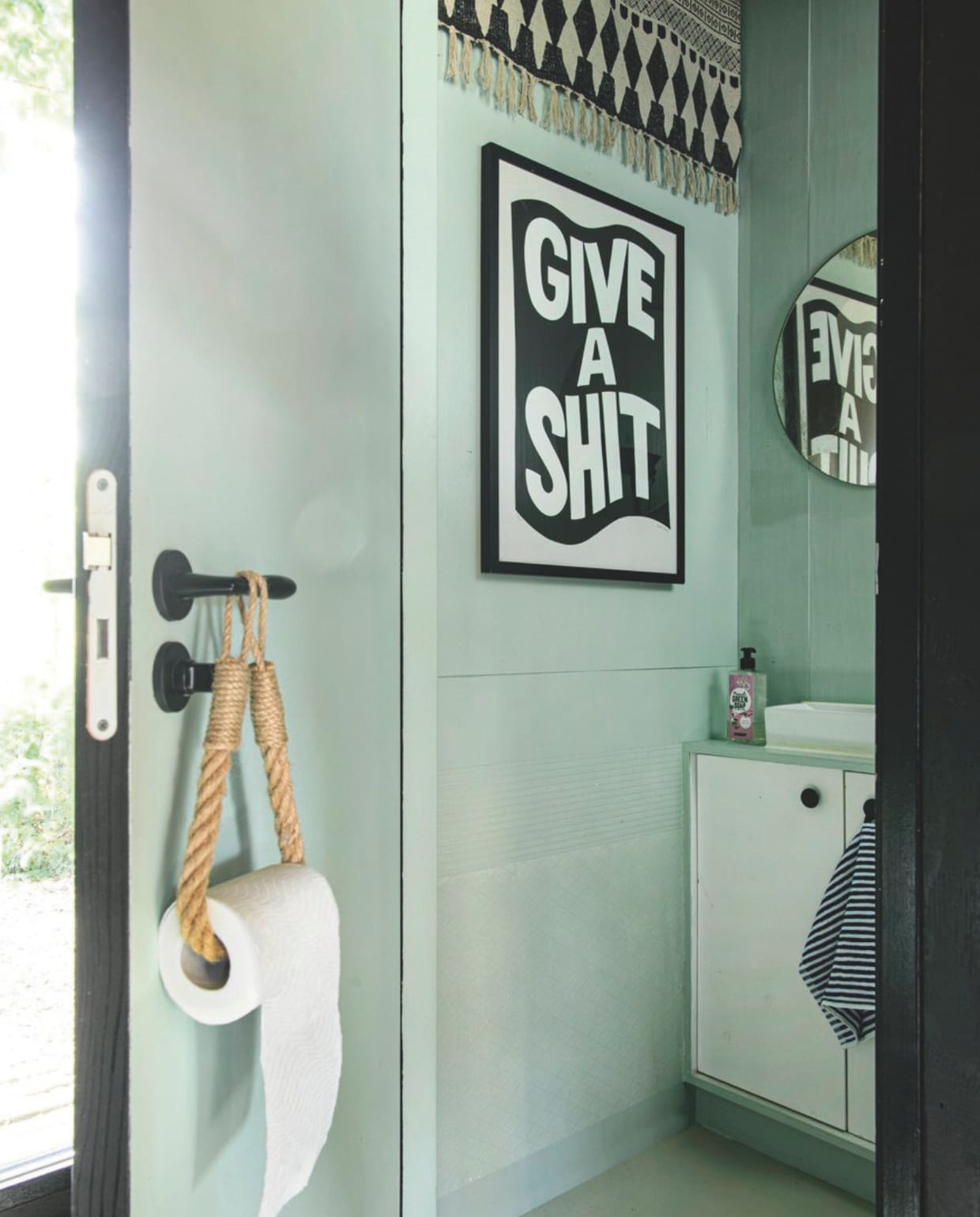 Wc-rolhouder kringloop, badkamerkastje zelfgemaakt, schilderij Adam Hayes, vloerkleed Wehkamp. vtwonen 06-2025 | styling Fiona Richardson | fotografie Lisa Cohen