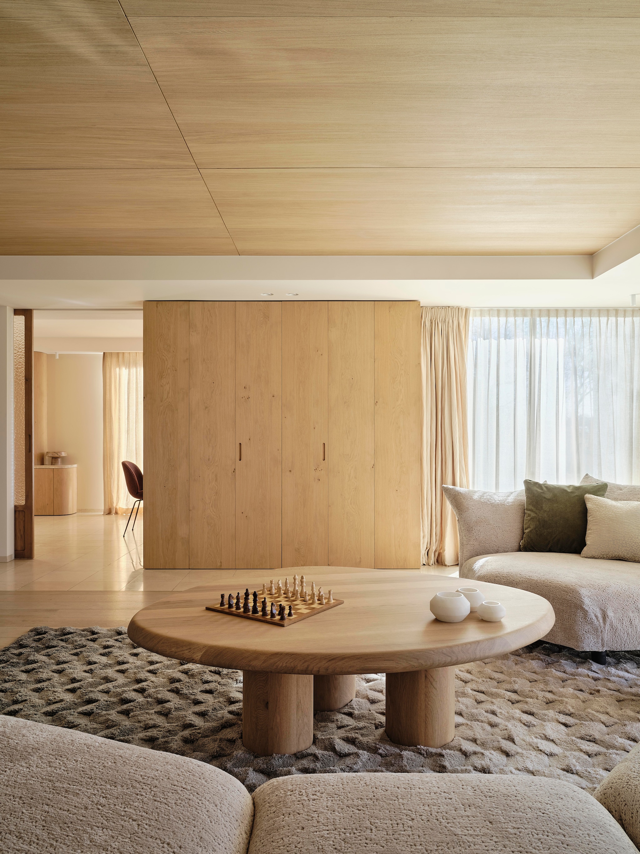 Modulaire bank Edra. Kussens gemaakt door Stoffeershop en bekleed met stof van Dedar en Zimmer + Rohde. Kleed Ferreira de Sá. Tafel Behout. Vazen Serax. Items planken links Maravillas, items planken rechts Roomer Art, Serax, HKliving. Tafellamp Oluce Atollo. Schouw Dover wit marmer. Zeegras behang Kudzu van Arte. stijlvol wonen 7-2025 | fotografie Space Content Studio