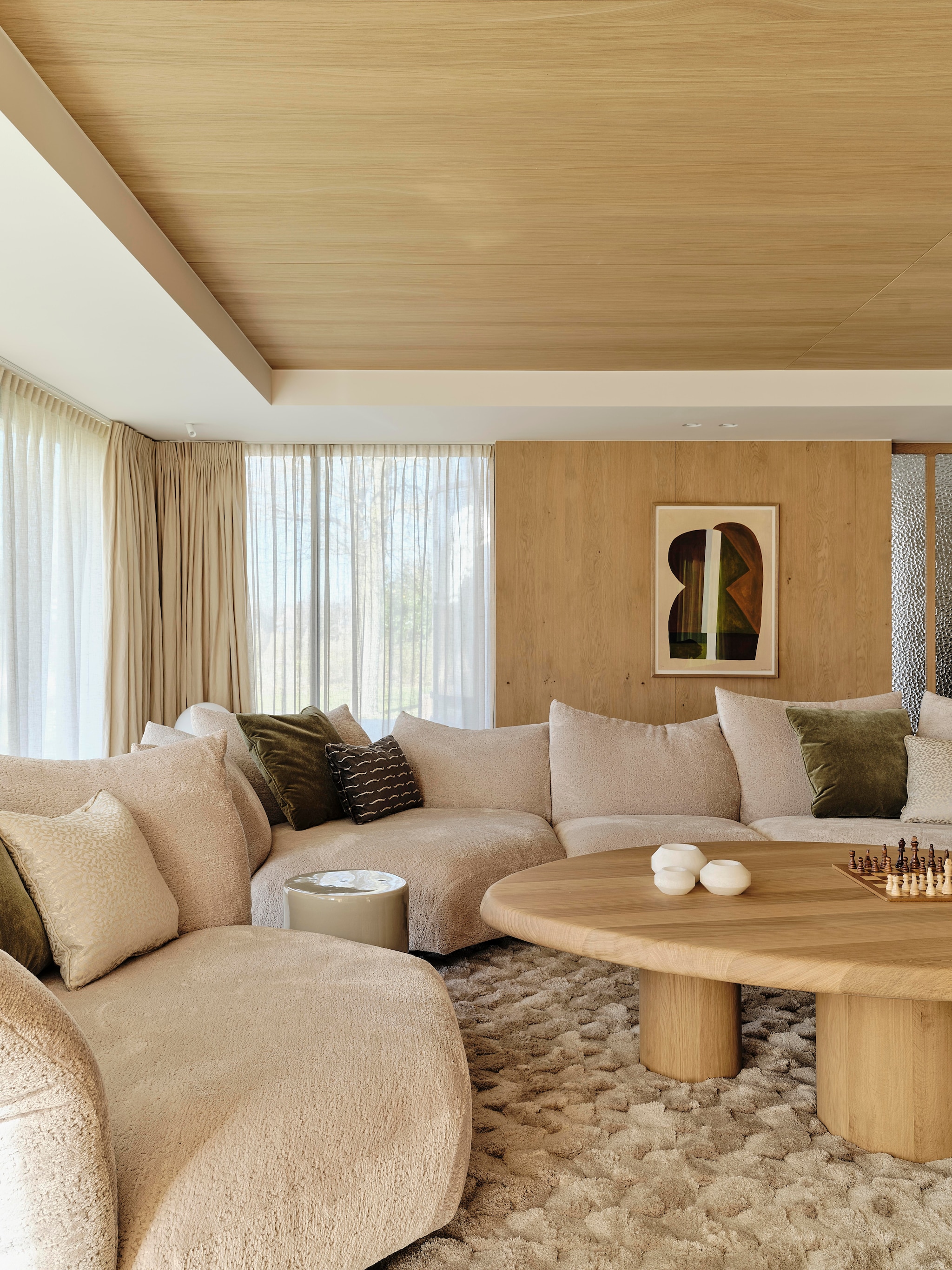 Modulaire bank Edra. Kussens gemaakt door Stoffeershop en bekleed met stof van Dedar en Zimmer + Rohde. Kleed Ferreira de Sá. Tafel Behout. Vazen Serax. Items planken links Maravillas, items planken rechts Roomer Art, Serax, HKliving. Tafellamp Oluce Atollo. Schouw Dover wit marmer. Zeegras behang Kudzu van Arte. stijlvol wonen 7-2025 | fotografie Space Content Studio