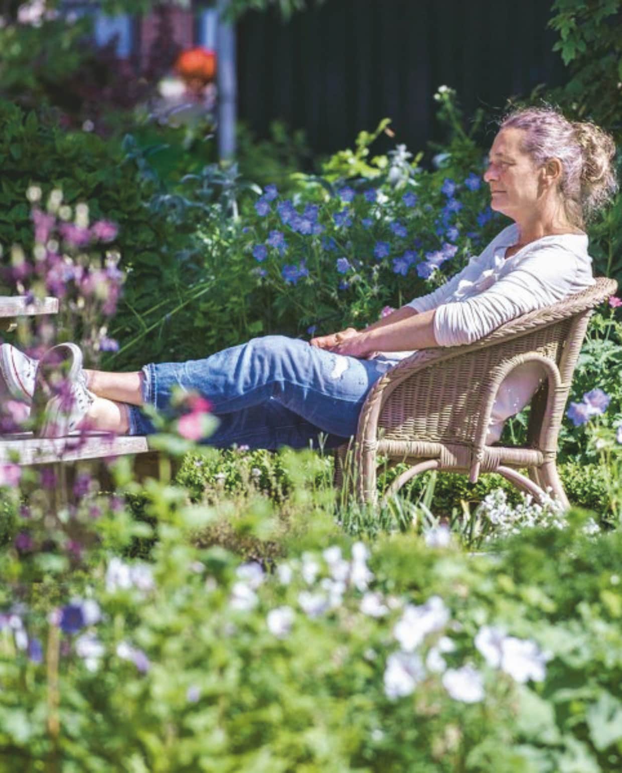 Mieke op een tuinstoel in haar tuin. vtwonen Landelijk 06-2025 | fotografie Ton Bouwer