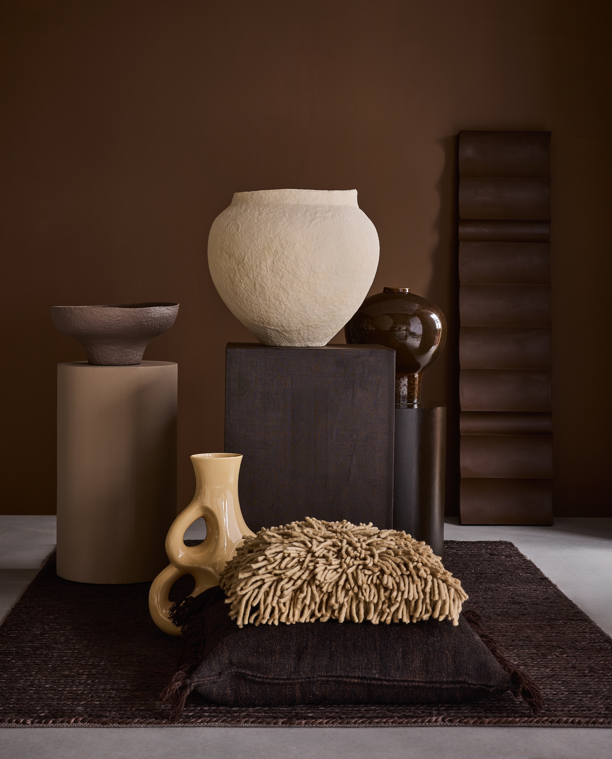 Lab Paint muurverf, Epic Tiger, 1 liter € 56,-, sokkels muurverf, Nude Cashmere en Charcoal, 1 liter € 56,- (vestingh.nl). Momo Rugs vloerkleed, hennep, bruin, 170x240 cm € 550,- (shop.vtwonen.nl). Muurobject, kunststof, bruin, prijs op aanvraag (edithbeurskens.com). Urban nature culture vaas Sandia, papier-maché, naturel € 245,-, schaal, papier-maché, bruin € 245,-, pot Ama, aardewerk, bruin € 169,99 (shop.vtwonen.nl). Polspotten vaas Three Ears, aardewerk € 250,- (polspotten.nl). Loods 5 kussen kelim, jute, bruin € 149,- (loods5.nl). HKliving kussen Rugged, wol en katoen, naturel € 79,95 (hkliving.nl). vtwonen 09-2025 | styling Marianne Luning | fotografie Alexander van Berge