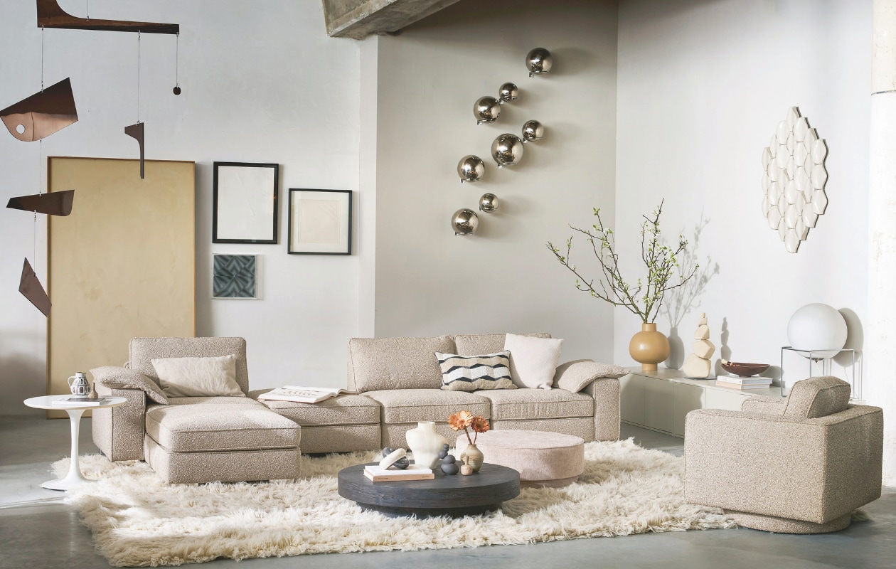 vtwonen elementenbank Lazy, zoals hier samengesteld: eenzit element met armleuning links, bouclé, naturel 65x103x94 cm € 719,-, hocker Lazy, bouclé, naturel, 40x90x90 cm (bxdxh)€ 429,-, eenzit element, bouclé, naturel, 65x83x94 cm (bxdxh) € 599,-, eenzit element met armleuning rechts, bouclé, naturel, 65x103x94 cm (bxdxh) € 719,- totaalprijs zoals hier samengesteld € 2895,-. vtwonen draaifauteuil Lazy, bouclé, naturel, 80x85x79 cm (bxdxh) € 649,-. vtwonen poef Pearl, chenille, natural melange, 80x28 cm (Øxh) € 199,-. vtwonen salontafel Shield Too, mdf, donkerbruin, 100x20 cm (Øxh) € 359,-. vtwonen tv-meubel/bank Settle Down, grenenhout, dust, 200x44x45 cm (bxdxh) € 599,-.M.m.v. cocooncollectables.nl (vloerkleed, bijzettafel, grote mobile, zilveren bollen, tegeltableau, lamp, vintage vaasjes, schilderijen), urbannatureculture.nl (crème vaas, okergele vaas en schaal), mettesophie.com (keramieken sculptuur). Overig privébezit. vtwonen collectie 07-2025 | styling Cleo Scheulderman | fotografie Jeroen van der Spek