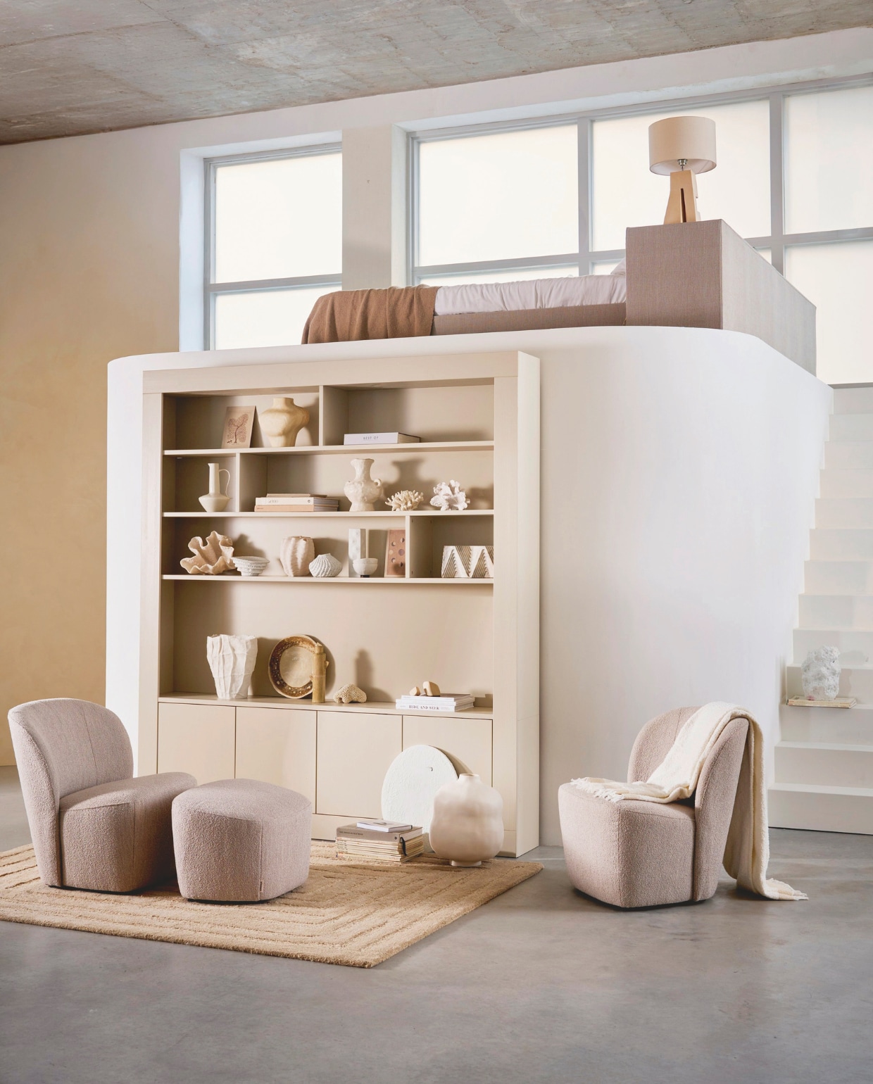 vtwonen fauteuil Lofty, bouclé, naturel gemêleerd, 68x72x75 cm (bxdxh)€ 299,-. vtwonen hocker Lofty, bouclé, naturel gemêleerd, 62x48x41 cm (bxdxh) € 169,-. vtwonen wandkast Wallcover, grenen, dust, 229x30,5x210 cm (bxdxh) € 1499,-.M.m.v. woood.nl (vloerkleed Alicia), metteditmer.com (koraal en schelp-objecten en grote vaas op onderste plank), zarahome.com (ronde schaal), urbannatureculture.nl (vaas op bovenste plank en op de grond), hm.com (kleine vaas, schaal en plaid), cocooncollectables.nl (overig). vtwonen collectie 07-2025 | styling Cleo Scheulderman | fotografie Jeroen van der Spek