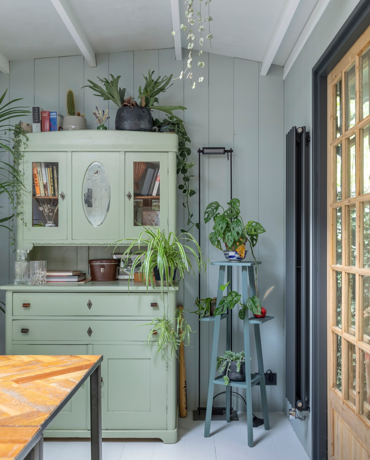 Tuinhuis ontworpen door Philip en gemaakt door timmermannen Jan en Rob. Deuren ’t Achterhuis. Planken op muur van oude schuren via Historisch Hout, net als de scheepsplanken op de veranda. Glas-in-loodraampje Marktplaats. Hanglamp Taiwan-lantern. Bureaus gemaakt door Mariekes vader. Schilderij aan muur uit Philips familie. Plantenhangers Mica. Wandlamp rommelmarkt IJ-Hallen. Strandstoel al jaren in bezit, herkomst onbekend. vtwonen 04-2020 | fotografie Margriet Hoekstra