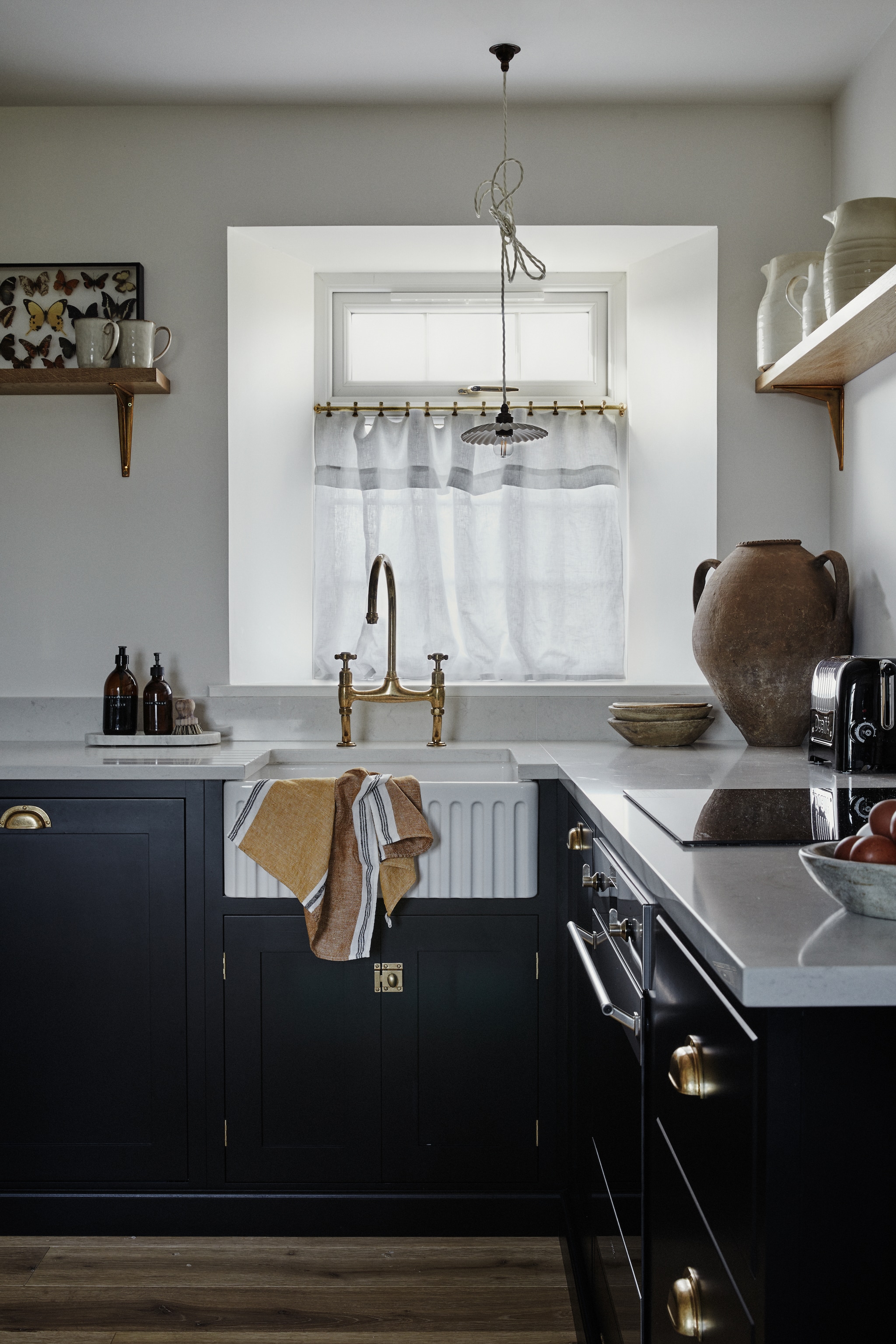 Handgeschilderde keuken met natuurstenen blad en messing details van Devol. Hanglamp Alex MacArthur Interiors. Pot Millington and Hope. vtwonen Landelijk 9-2025 | productie Living Inside | styling Ali Heath | fotografie Brent Darby
