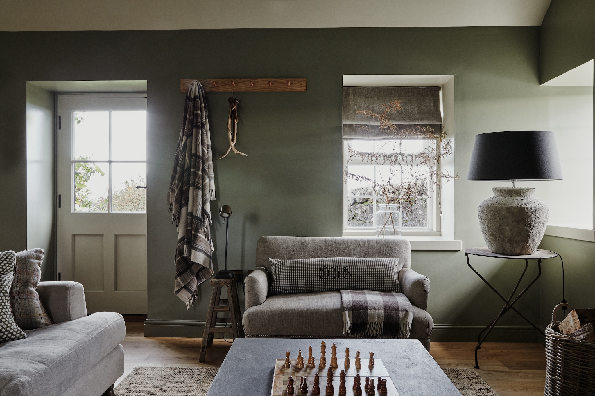 Antieke linnen bank Emma Leschallas. Linkerbank sofa.com. Kruk Baileys Home Store. Antieke tafel Maison Artefact. Lamp Ali Heath. Stof van kussens en gordijnen van klassieke, Engelse merken als Fermoie, Colefax and Fowler en Parker & Jules. vtwonen Landelijk 9-2025 | productie Living Inside | styling Ali Heath | fotografie Brent Darby