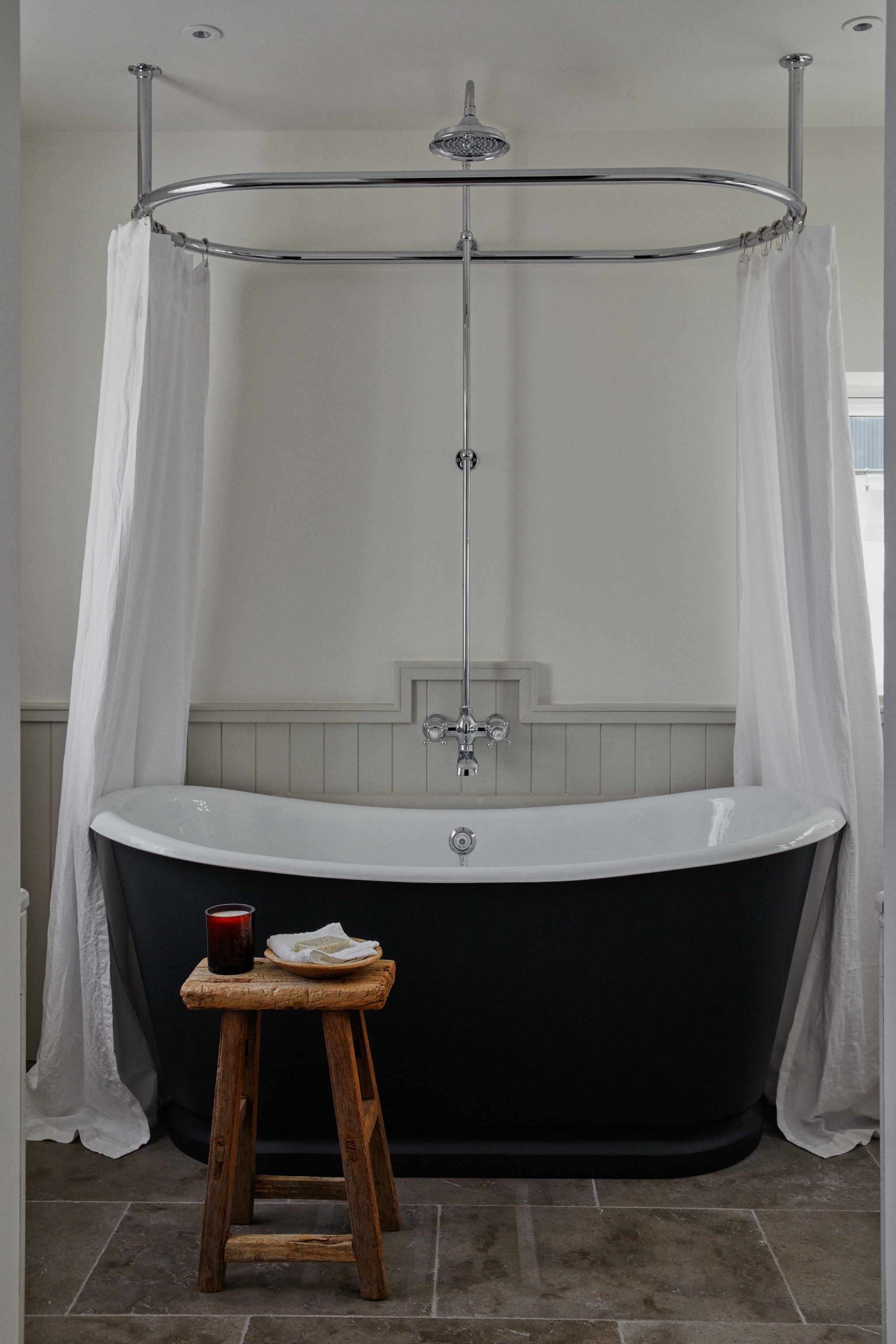 op lambrisering Blackened van Farrow & Ball, scheepslamp Alessio van Las Sola, spiegel Barok Spiegel, trap Zara Home. vtwonen Landelijk 9-2025 | productie Living Inside | styling Ali Heath | fotografie Brent Darby
