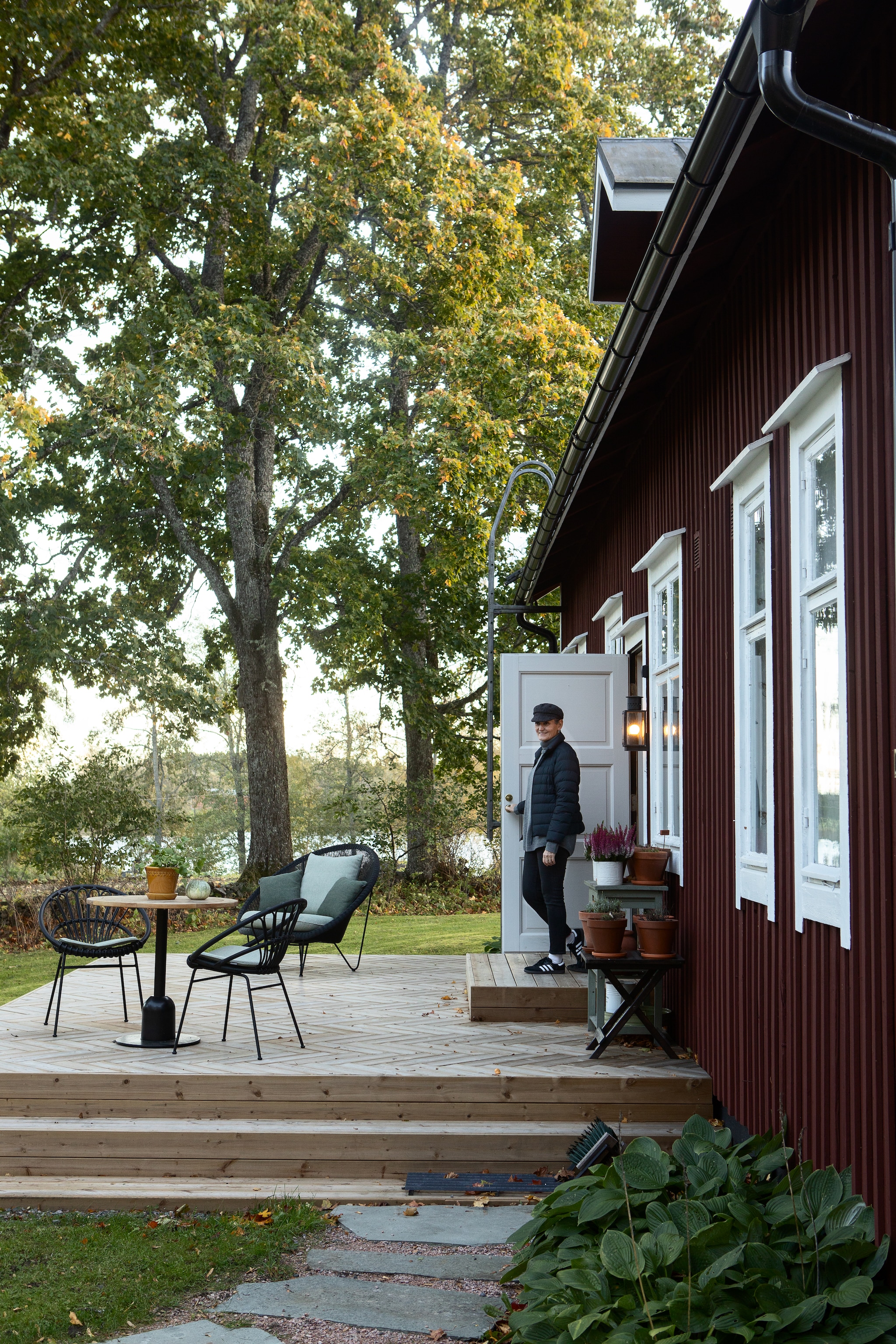 Charlotta op het ruime terras. Tuinmeubels Vincent Sheppard. vtwonen Landelijk 9-2025 | productie Studio Rautio | fotografie Heikki Rautio