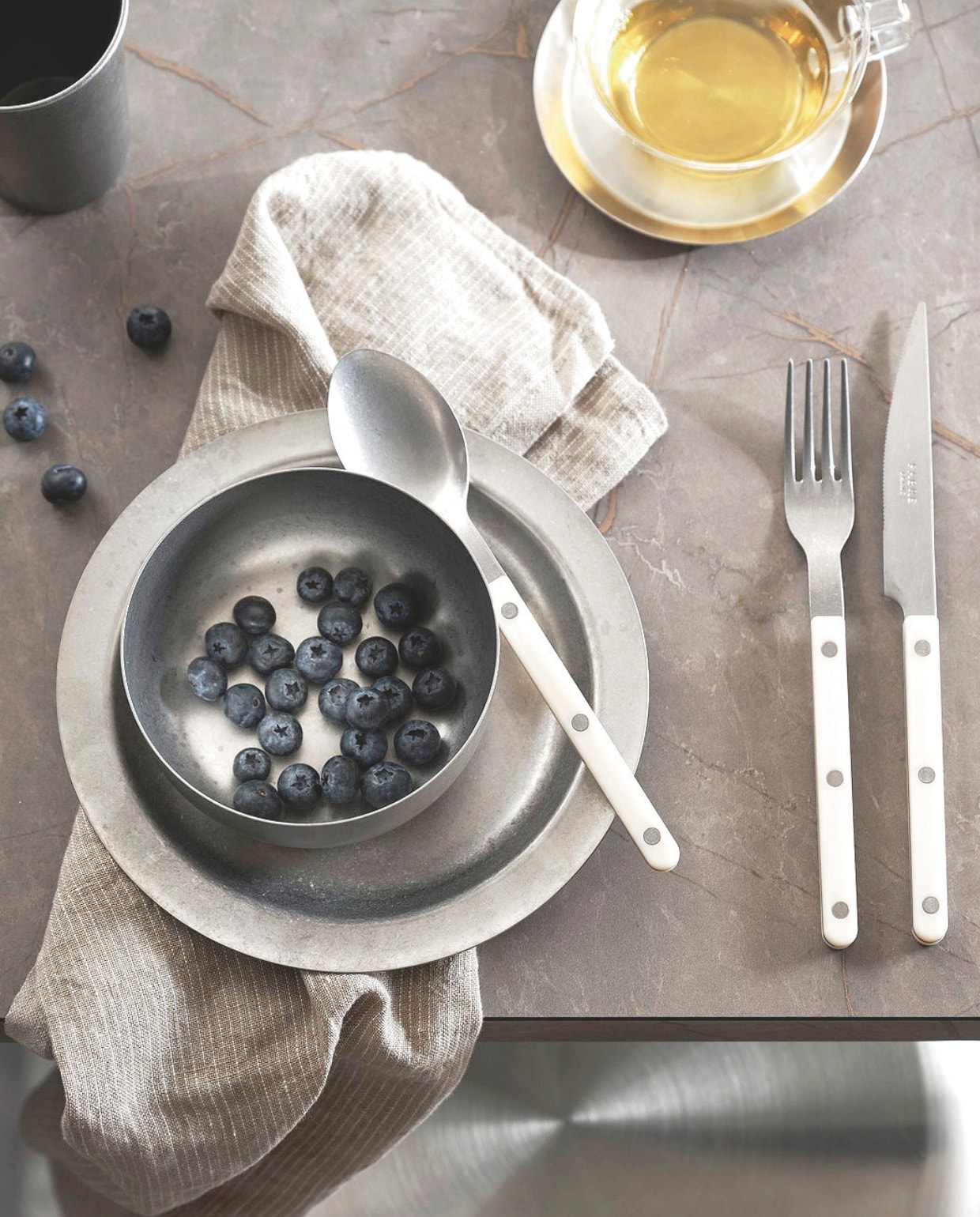 vtwonen keuken Tricolore, in drie kleuren, in deze opstelling € 23.500,- M.m.v. thefinestore.com (By Mölle theedoek Pinstripe Flax, Ferm Living rvs kom, bord en beker Tumbled, Sabre Paris bestekset Bistrot, Kinto theeglas met rvs schotel Cast). vtwonen 07-2025 | styling Kim van Rossenberg | fotografie Sjoerd Eickmans
