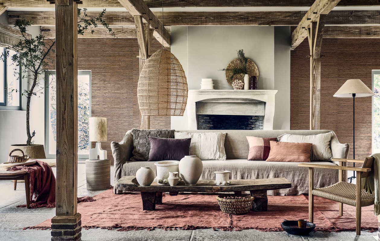 Papieren behang Natural Wallcoverings 3 in 303549, 550x91 cm (lxb), per rol € 160,- (eijffinger.com). 3-Zitsbank Coen, 220x95x80 cm (bxdxh) € 3999,- (lauthentique.nl). Ligbed Tangāli van Phantom Hands, teakhout en natuurlijk riet, 190x74,5x41 cm (lxbxh) € 3380,- (hetarsenaal.nl). Handgemaakte eiken loungestoel, 76,5x64,5x64 cm (lxbxh) € 899,-, schaal op ligbed prijs op aanvraag (sukha.nl). Lamp met driepoot, metaal en katoen, 41x155 cm (Øxh) € 179,-, grijze vaas, set van 2 vanaf € 39,99, ecru ongelijkvormige vaas van aluminium, set van 2 vanaf € 22,99, gebroken witte vaas met textuur, set van 2 vanaf € 17,99, ronde mand van banenblad € 39,99, bruine jute kussenhoes € 49,99, ecru linnen kussenhoezen € 15,99, oudroze linnen kussenhoes met ruit € 22,99, paarse kussenhoes € 29,99 (zarahome.com). Katoenen plaids van Malagoon in Timber Terracotta en Clay White, 152x127 cm, per stuk € 39,95, papier-maché bloempot Construct van Serax € 469,-, beige stenen bijzettafel Pawns van Serax, 32x39 cm (Øxh) € 349,-, beige aardewerken vazen Molly van Serax, pot 05 maat M € 90,-, pot 05 maat L € 245,-, pot 06 maat M € 65,-, okerkleurige keramische kop Merci nº9 van Serax € 10,-, geglazuurd keramieken bord Terres de Rêves van Serax € 26,99 (vtwonen.nl/shop). Mangohouten schaal Modern Rustic € 79,-, tafellamp Hikari, steen en zijde, 55x22,5 cm (Øxh) € 189,-, decoratief ecomix object Calcolo, set van 2 € 84,95, handgeweven zijden kussen Almond € 72,95 (urbannatureculture.com). Houten tafel Naga, 188x52x28 cm (lxbxh) € 2995,-, rood hennep vintage tapijt uit Turkije, 225x177 cm vanaf € 990,-, macramé hanglamp, raffia met metalen structuur, 50x70 cm (Øxh) € 395,-, bruine keramische vaas Terre de Sienna € 59,-, rode aardewerken lepel Merci L € 15,-, wandschaal Porcupine, ilala palm € 149,- (couleurlocale.eu). Vaas en kan (kringloopcentrumbollenstreek.nl). Overig privébezit. vtwonen 09-2023 | styling Liza Wassenaar | fotografie Sjoerd Eickmans