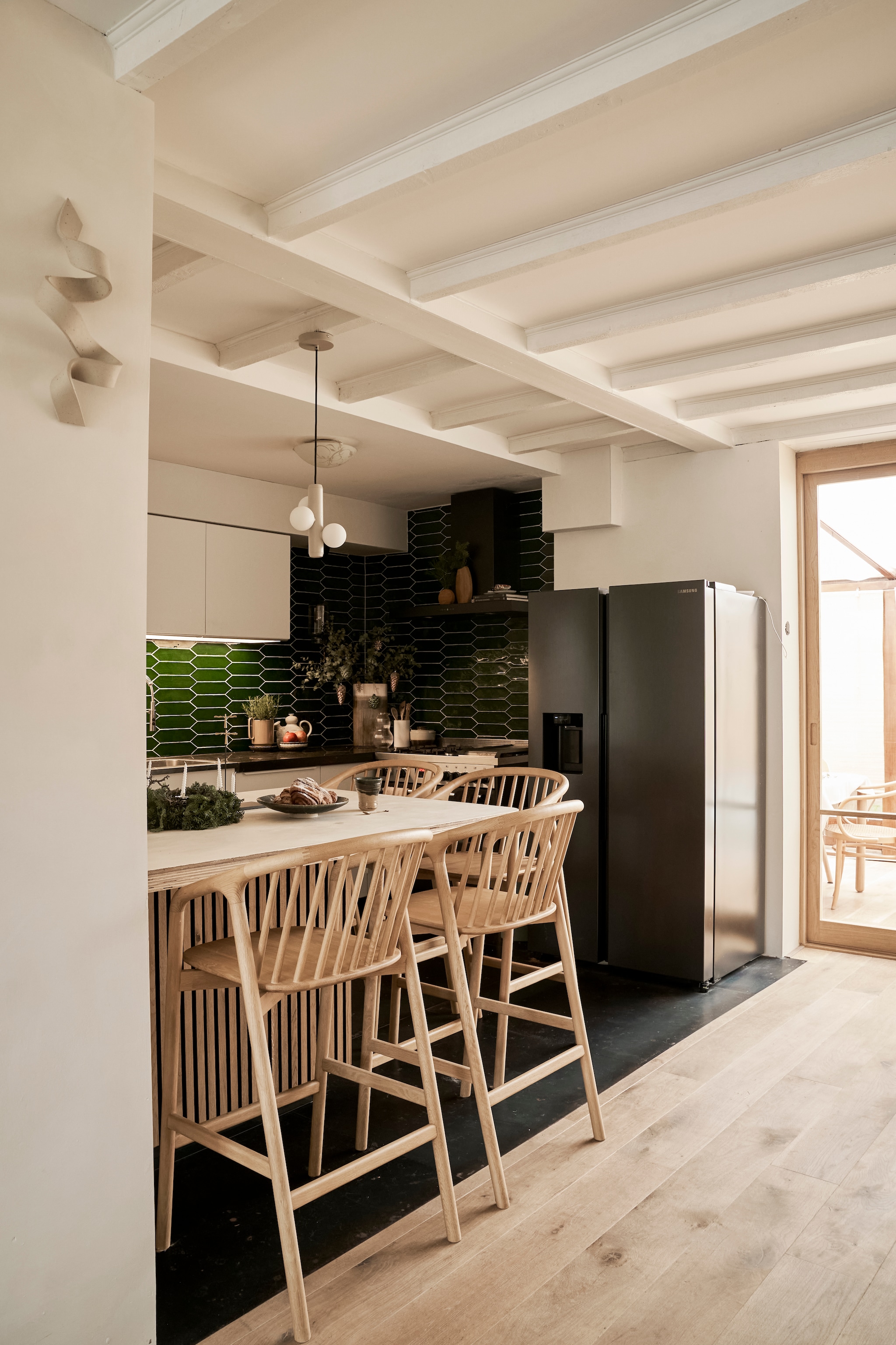 Bar ontworpen door Laila. Krukken Made. Lamp Fést. Bank Ikea. Kunstwerk Dwarrelende Sneeuw van Kamisaka Sekka. Staande lamp Floss. vtwonen 11-2025 | styling Kamer465 | fotografie Muk van Lil