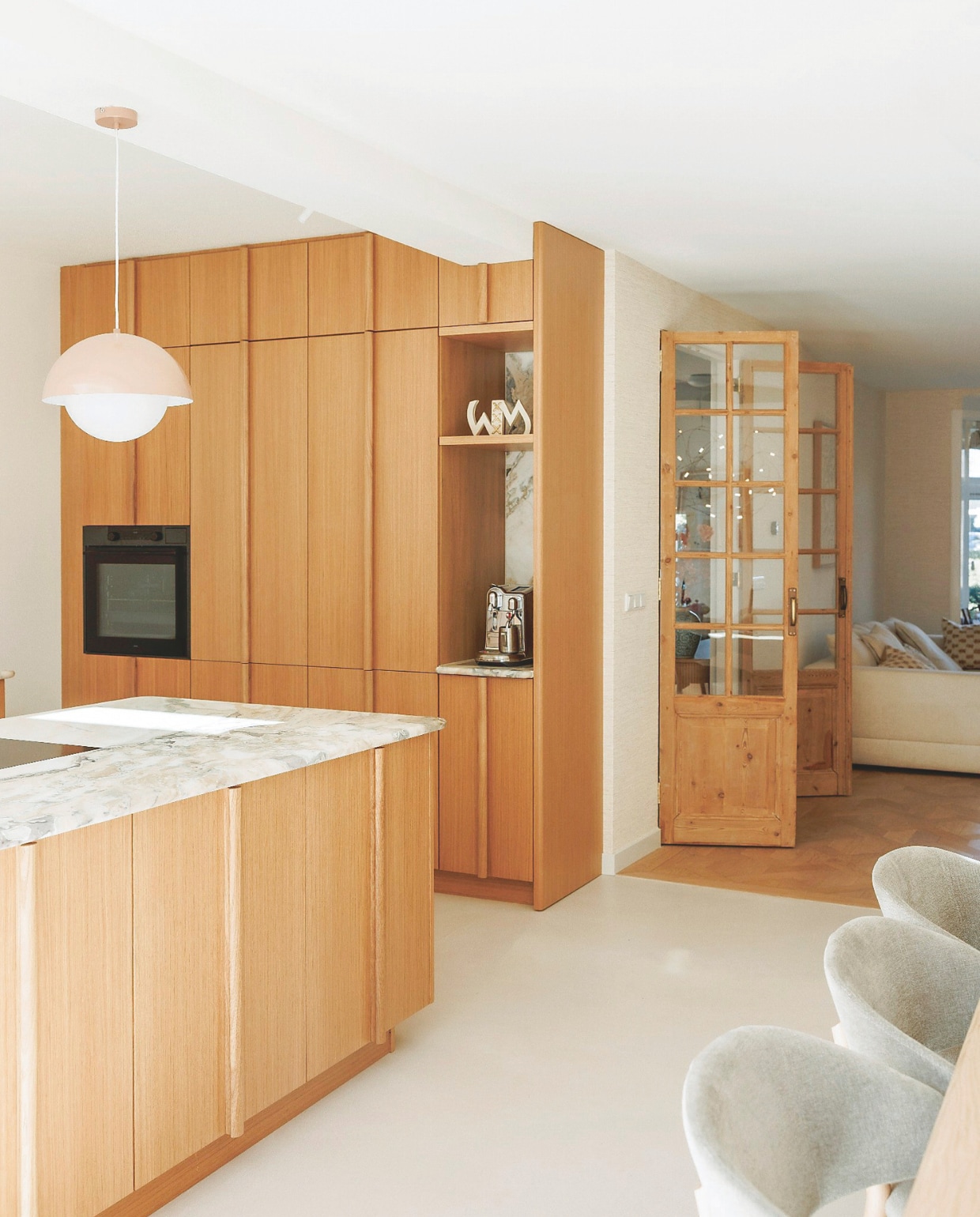 Maatwerkkeuken Reform, keukenblad Jan Reek natuursteen, keukenapparatuur Atag. Houten deuren naar gang Oudedeur. Beeldje cadeau gekregen. Hanglamp Westwing. vtwonen 7-2025 | fotografie Emma Peijnenburg