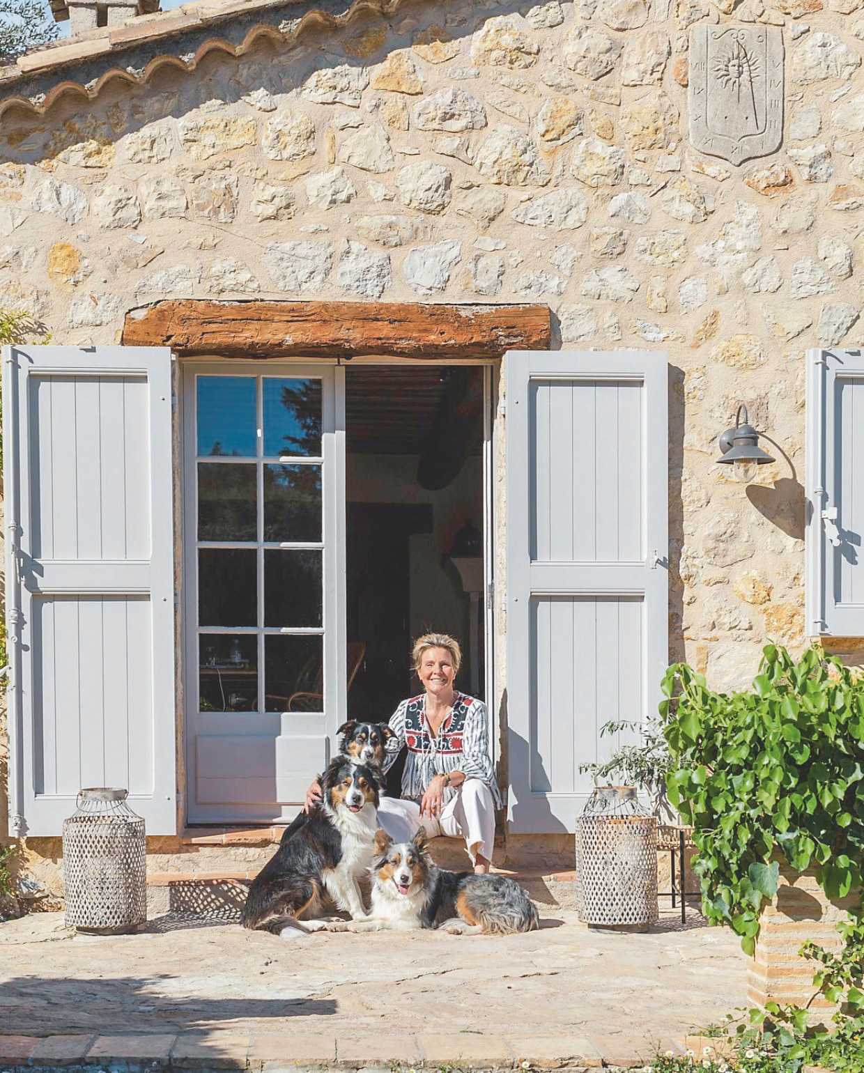Moeder en pups bordercollie poseren braaf met Judith bij de entree van l’Escale du Ciel. vtwonen landelijk 7-2025 | styling Elen Pouhaer | fotografie Marta Puglia