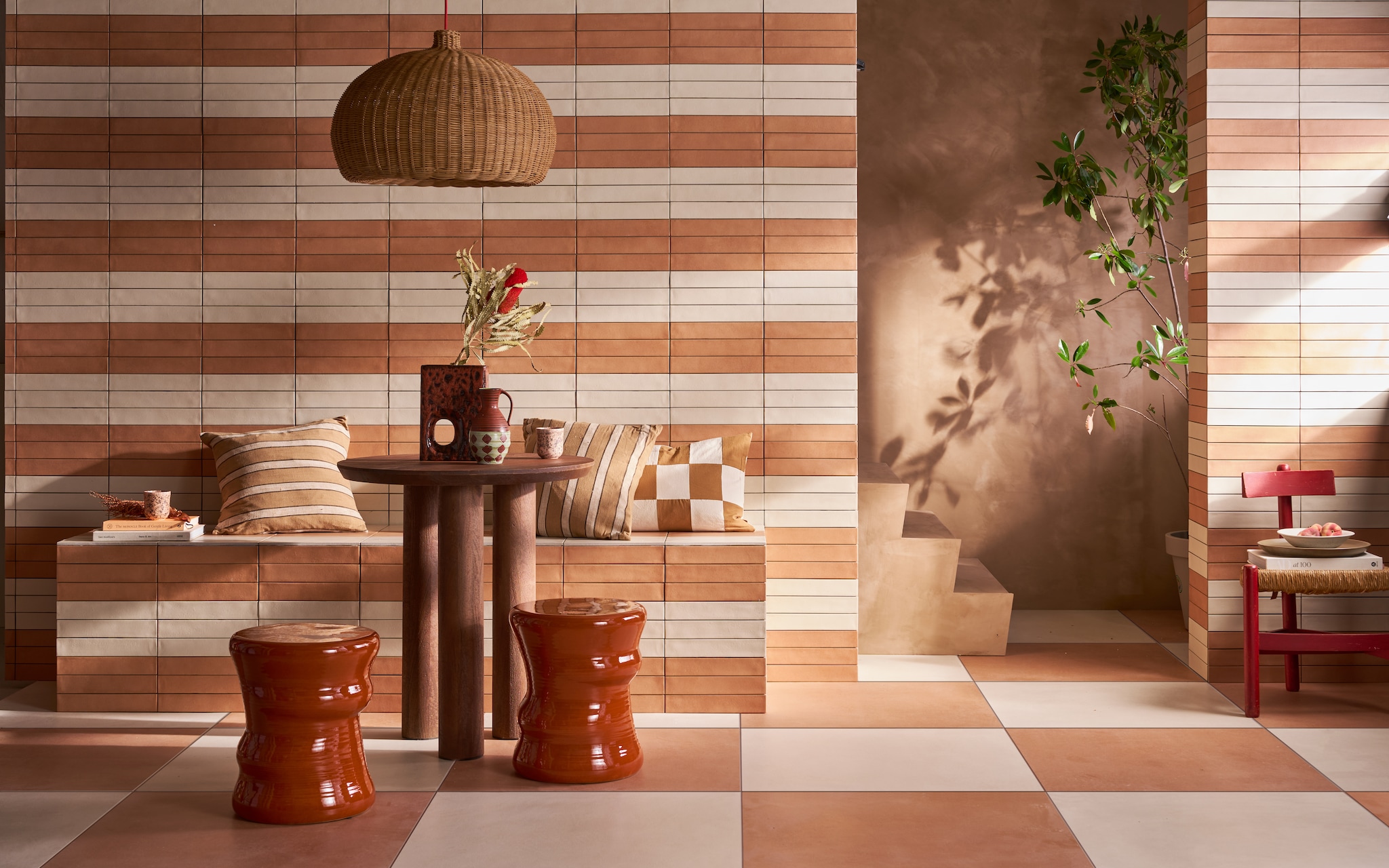 Op de vloer tegels Earth Pomice en Earth Cotto, 75x75 cm, per m² € 77,50. Op de wand en bank tegels Earth Pomice en Earth Cotto, 5x30 cm, per m² € 79,50..M.m.v. lauthentique.nl (kalkverf muur en trap in Mokka), nordal.com (eettafel Helin Cafe), vtwonen.nl/shop (krukken Pawn van Serax, lampenkap Belly en kussens van Ferm Living, vaas van HKliving, beker en diep bord van vtwonen), graublau.nl (vintage stoel). vtwonen 09-2024 | styling Cleo Scheulderman | fotografie Jeroen van der Spek