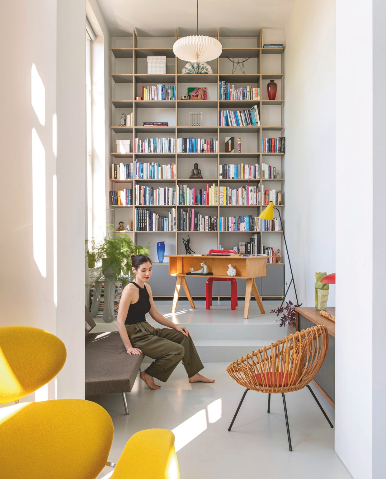Boekenkast op maat gemaakt. Bureau van Cees Braakman voor Pastoe. Chubby chair van Dirk van der Kooij, door Michelle aan Martijn cadeau gedaan. Vloerlamp Model 1503 van J.J.M. Hoogervorst, originele uitvoering uit 1955, Anvia. Papieren hanglamp de Bijenkorf. stijlvol wonen 7-2025 | styling Anke Helmich | fotografie Caroline Coehorst