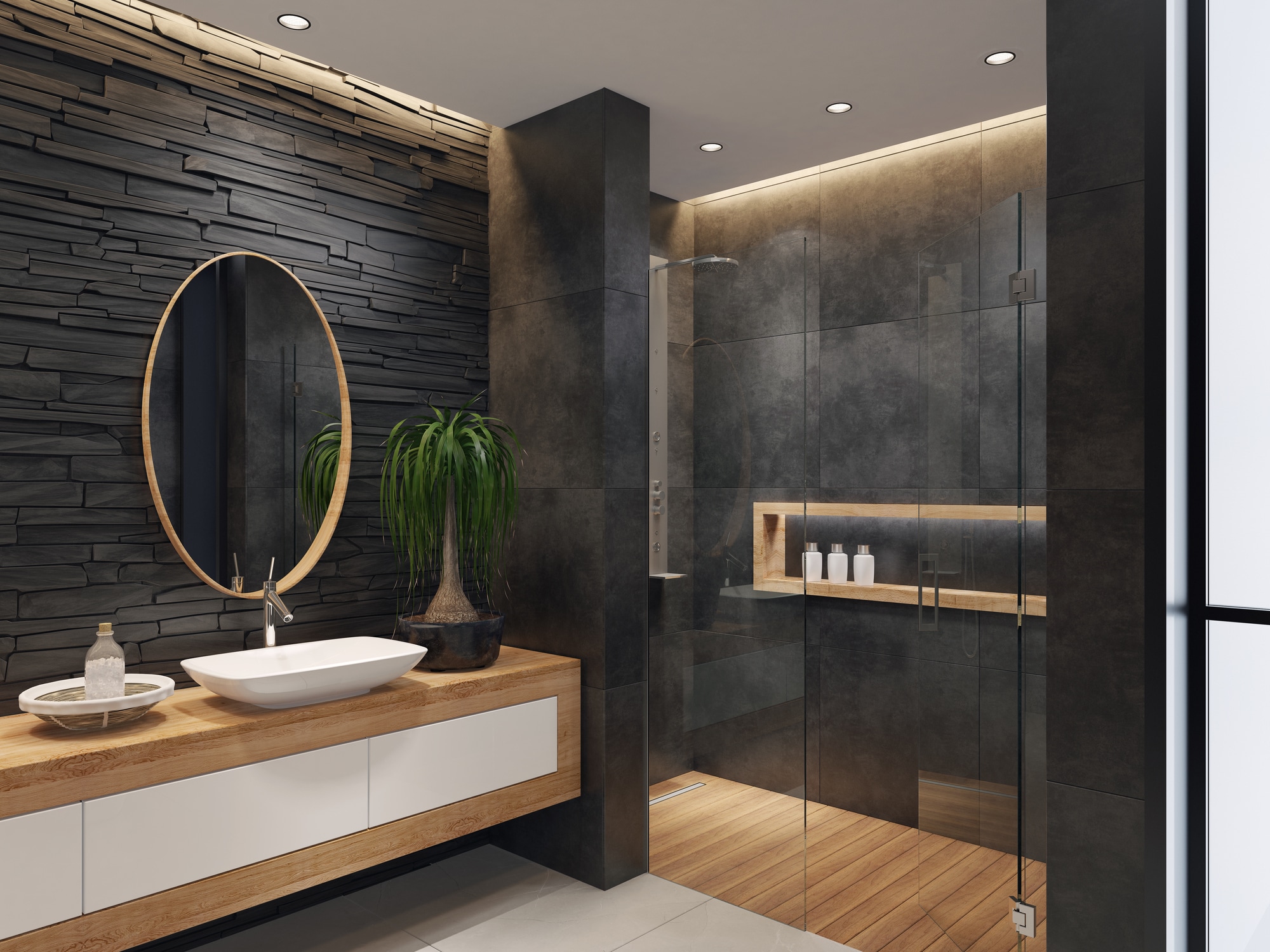 contemporary minimalist bathroom with two round mirrors and wooden frame.
natural stacked black matte stone wall with large black matte tiles.
two rectangular white wash basins are on top of the long wooden cabinet with
white doors. large white matte floor tiles. wooden floor tiles in walk-in shower.
ceiling strip cove lighting with embedded spotlights. Getty Images