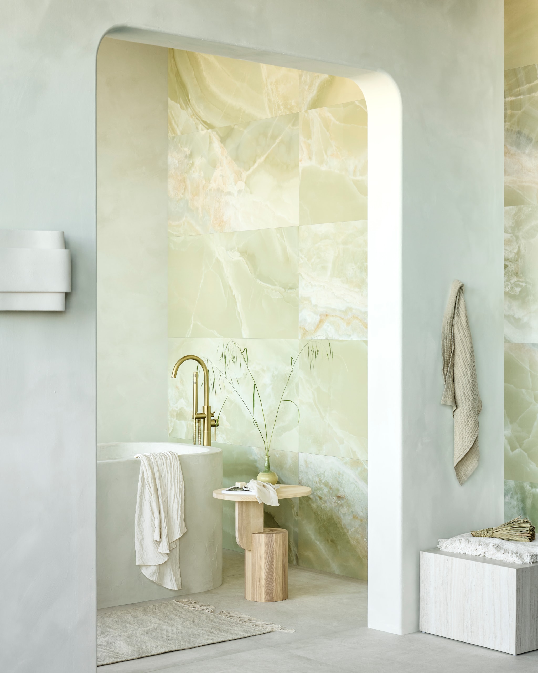Op de wand tegels Onyx Jade Green, 60x120 cm, per m² € 92,50. Op de vloer tegels Raw White Mat, 120x120 cm, per m² € 92,50.M.m.v. pure-original.com (muurverf Casablanca), tegeldepot.nl (vrijstaande badkraan van Boss & Wessing in geborsteld goud), vtwonen.nl/shop (bijzettafel Insert van Ferm Living, wandlamp van Serax, vierkante salontafel van Fonq), hm.com (wollen badmat, handdoek), ikea.nl (plaid). Overig privébezit. vtwonen 09-2023 | productie Tanja Saarberg | styling Sanne Ketelaar | fotografie Sjoerd Eickmans