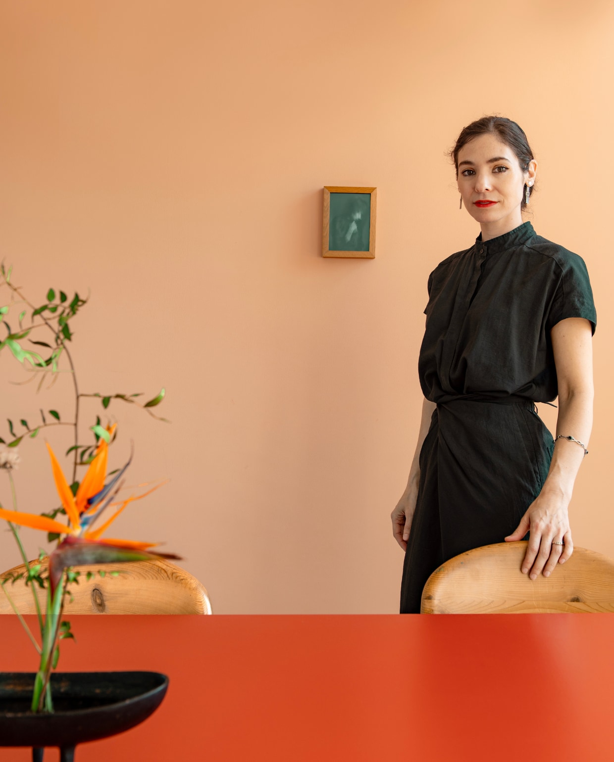 Tafel Slim van Arco via Marktplaats, geschilderd in het rood van Japans lakwerk vanwege een watervlek op het blad. Ikebana-schaaltje Isamu Noguchi. Foto Martijn Kappers. stijlvol wonen 7-2025 | styling Anke Helmich